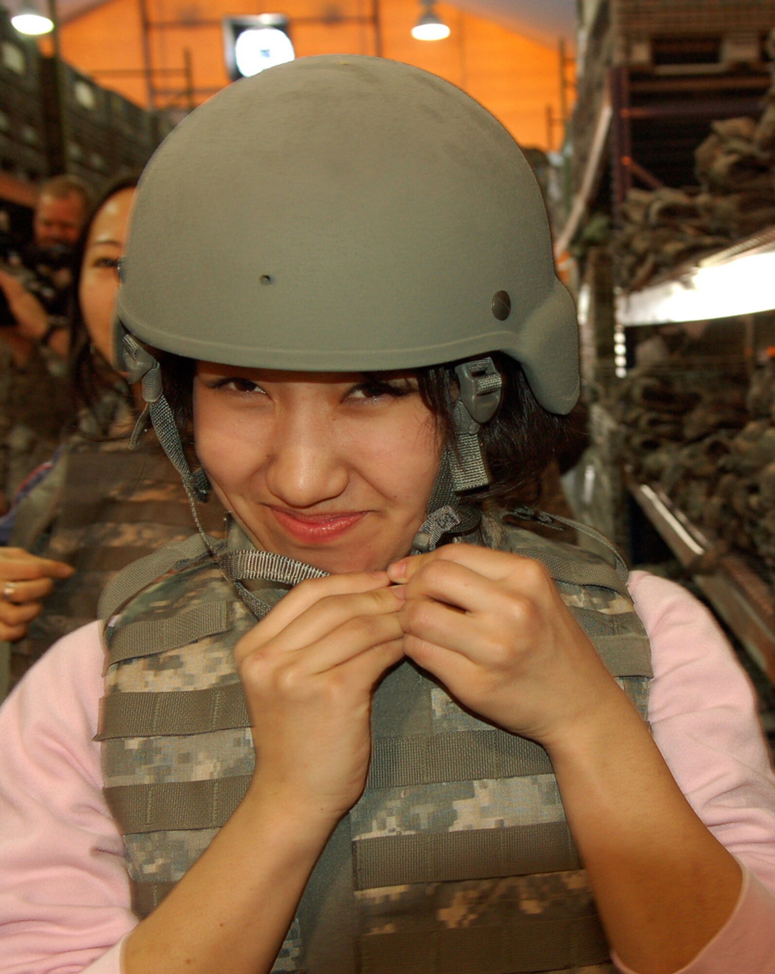 Aikanysh Atakanova experiences the 35-pound weight of the Individual Body Armor while visiting the Expeditionary Theatre Distribution Center at Manas Air Base, Kyrgyzstan, March 26. Ms. Atakanova, a student at the American University of Central Asia, visited Manas with 12 other students and faculty for an orientation tour and dinner hosted by the 376th Air Expeditionary Wing Public Affairs office. The visit provided the students a look at the missions carried out daily in support of operations in Afghanistan, while building friendships with coalition personnel deployed here. (U.S. Air Force/Tech. Sgt. Phyllis Hanson)