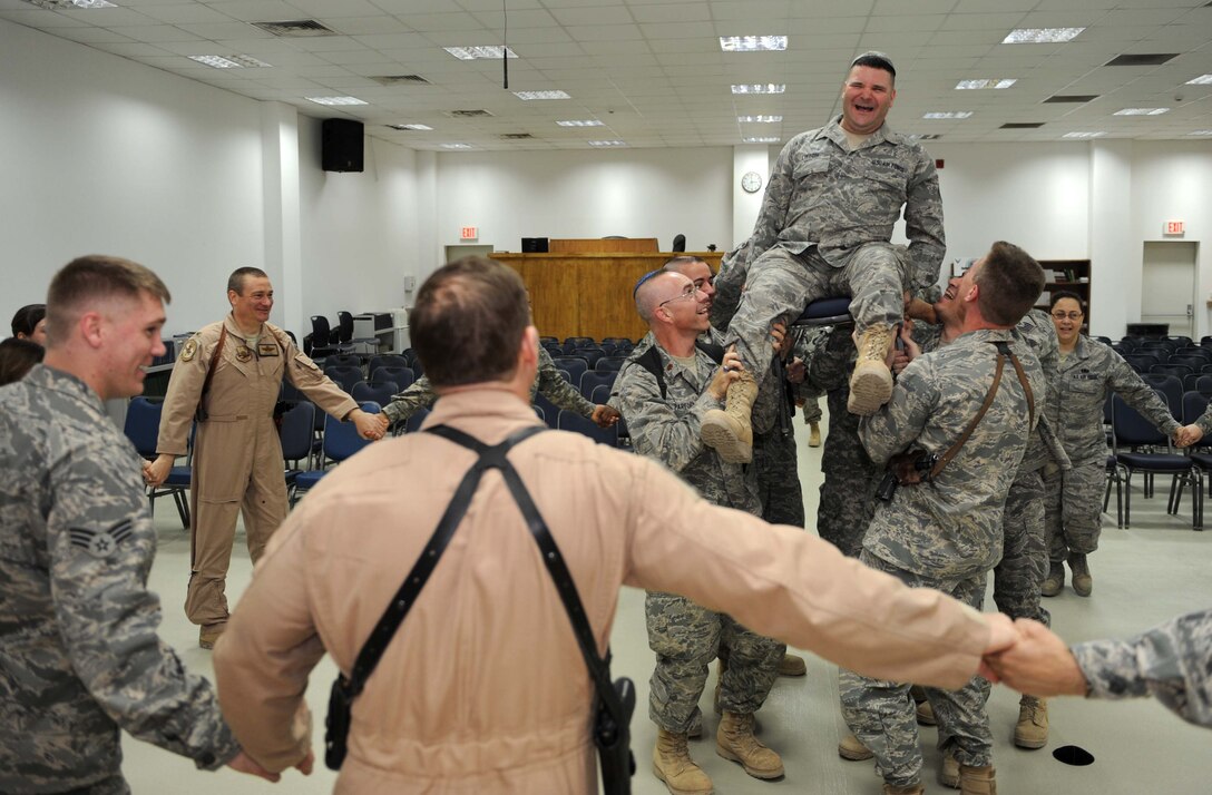 JOINT BASE BALAD, Iraq -- Tech. Sgt. Craig Lifton, 332nd AEW Public Affairs NCO-in-charge of journalism, laughs as he is hoisted up in the air by fellow servicemembers during his bar mitzvah here March 21 at Gilbert Memorial Chapel. The bar mitzvah took place after a dedication ceremony here celebrating the arrival of a Jewish Torah. A bar mitzvah is a rite of passage held traditionally for Jewish boys when they reach 13 years old and a day. Bar mitzvah literally means, "son of the commandment," -- meaning the person is now of age to fully participate in all aspects of the Jewish religion. (U.S. Air Force photo/Senior Airman Elizabeth Rissmiller)