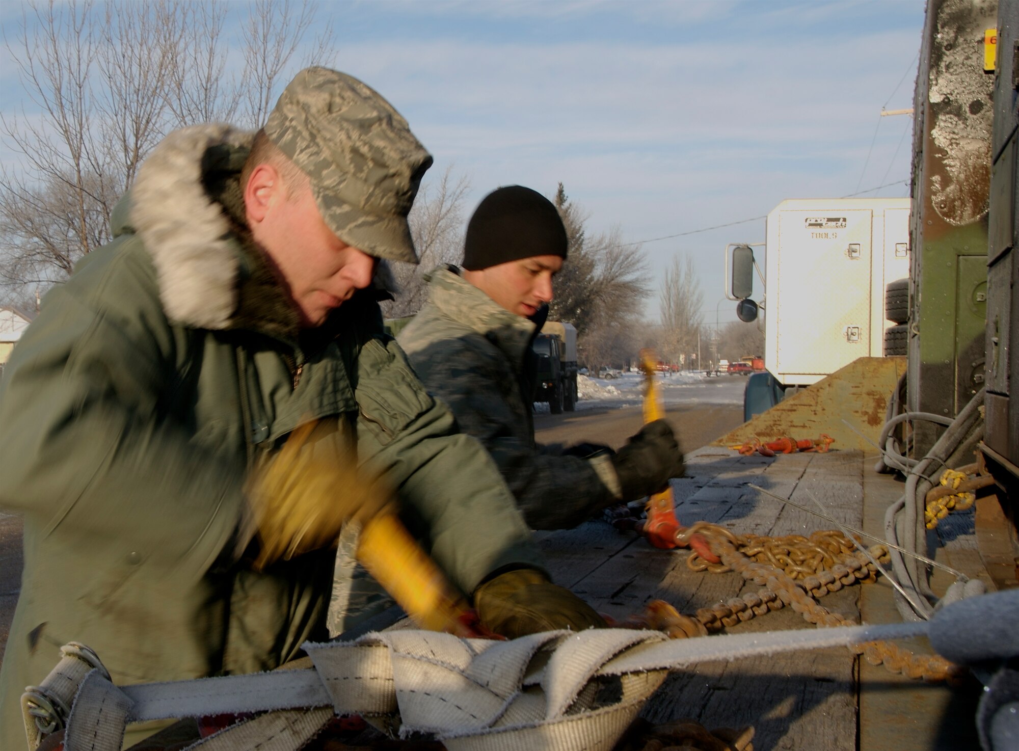 Technical Sgt. Ken Kelly and Staff Sgt. Tony Hallen, 133rd Logistics Readiness Squadron, Minnesota Air National Guard, remove tie down chains holding a 60-kilowatt generator in place on a flatbed truck. Staff Sgt. Hallen drove to Moorhead, Minnesota overnight in the early morning of the 28th of March 2009 from St. Paul, Minnesota to deliver these generators to provide needed power.
U.S. Air Force Photo by Tech Sgt Erik Gudmundson
