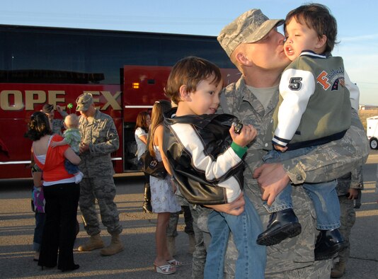 Tech. Sgt. Robert Johnson, 95th Security Forces Squadron, gives hugs and kisses to his sons, Sonny and Gavin, during a welcome home reception at the 95th SFS headquarters March 13. Forty-three 95th SFS Airmen returned from Iraq deployment at Ali Air Base and Camp Bucca. (U.S. Air Force photo/Lisa Camplin)