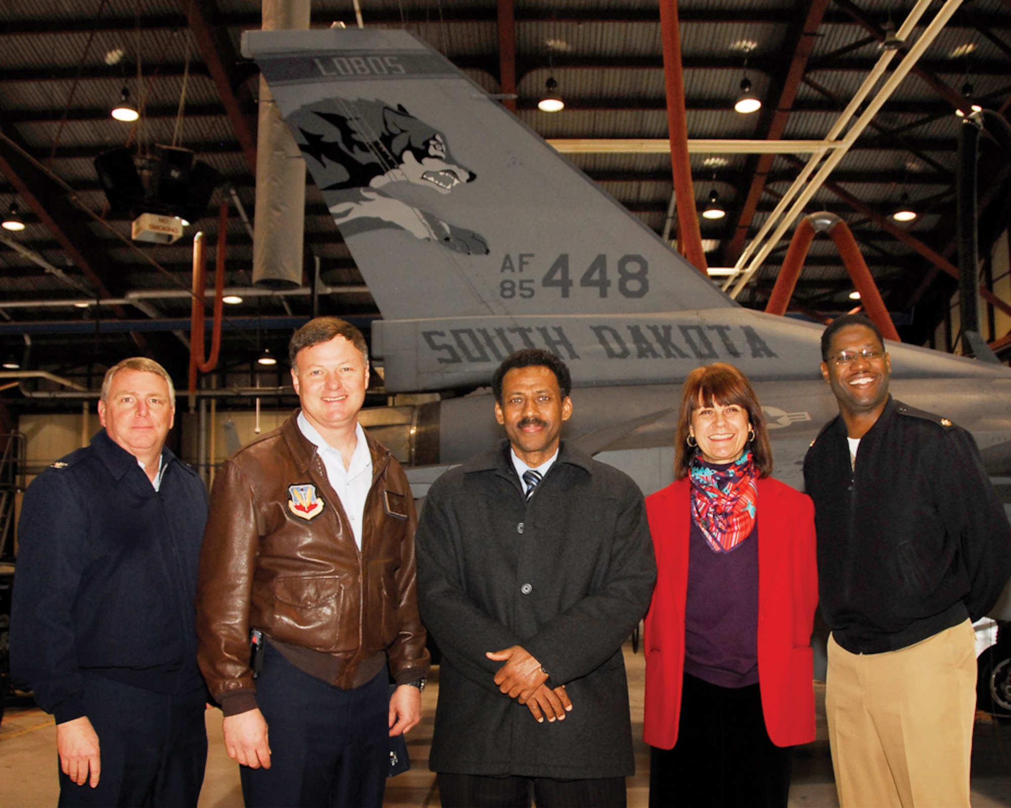 114th Mission Support Group Commander Col. Steve Warren, 114th Fighter Wing Commander Russ Walz, Suriname Defense Minister Ivan Fernald, U.S. Ambassador Lisa Bobbie Schreiber Hughes, and Navy Lt. Commander Waymon Jackson pose next to the tail of an F-16 Fighting Falcon here Feb. 25. Defense Minister Fernald and Ambassador Schreiber Hughes were here touring South Dakota as part of the Growth through Partnership program.