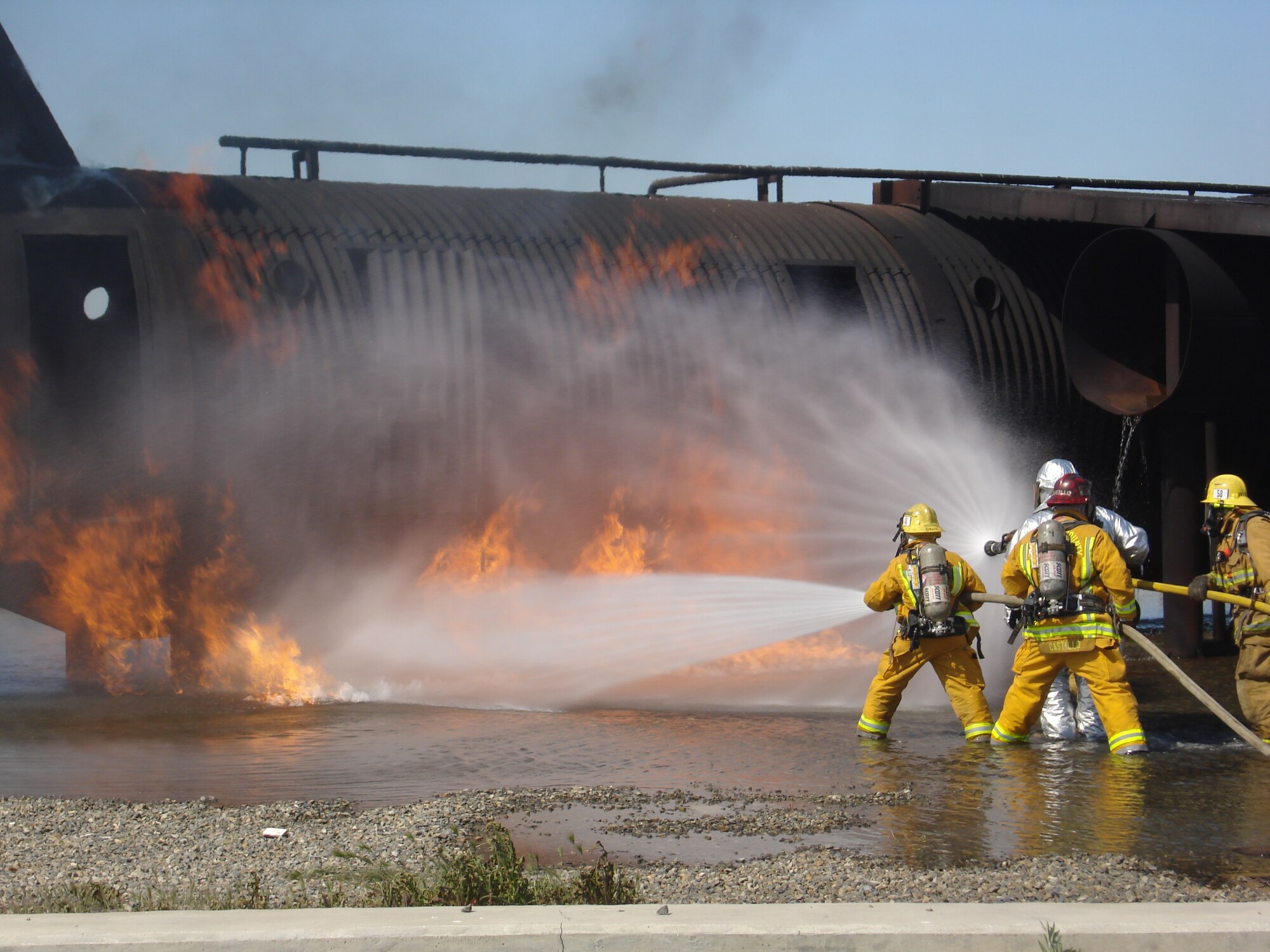 Fire fighters battle flames from a simulated crash. (U.S. Air Force photos by SSgt. Megan Crusher)