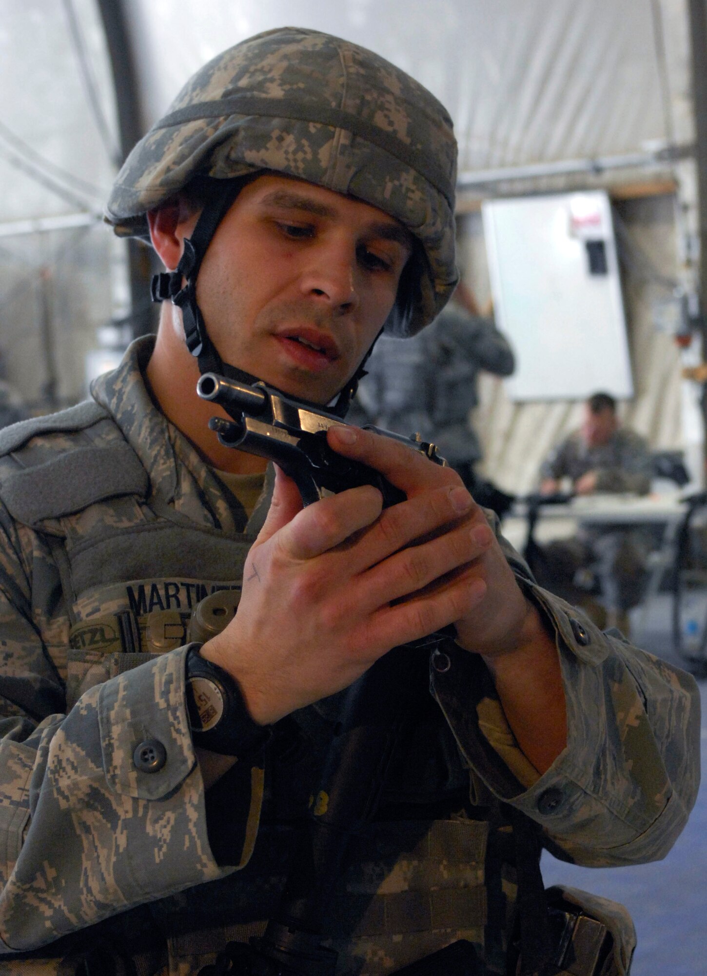 Staff Sgt. Dean Martinez, 455th Expeditionary Security Forces Squadron, clears the M-9 hand gun before disassembly at Bagram Air Field, Afghanistan, March 25. The Combined Joint Task Force-101 held a competition for junior enlisted and non-commissioned officer Soldiers, Airmen, Sailors, and Marines. Sergeant Martinez placed first in the NCO category. As a seven year veteran in Security Forces, Sergeant Martinez had no problem with the weapons portion of the competition.(U.S. Air Force photo/ Senior Airman Erik Cardenas)(Released)
