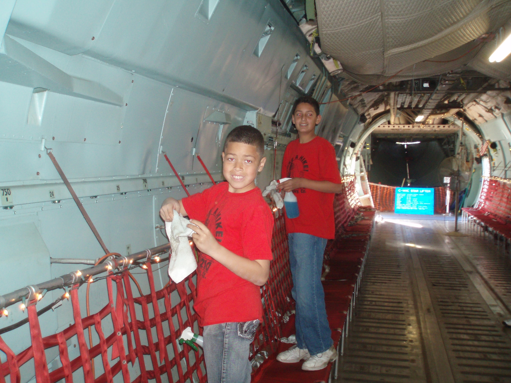 Desmond Ford (front) and Michael Gonzales clean a side panel of the interior in the C-141. Approximately 70 volunteers between the ages of 11 and 60 helped complete the project. The planning took five months and the cleaning took three weeks. (Courtesy photo provided by Jacob Medeiros)