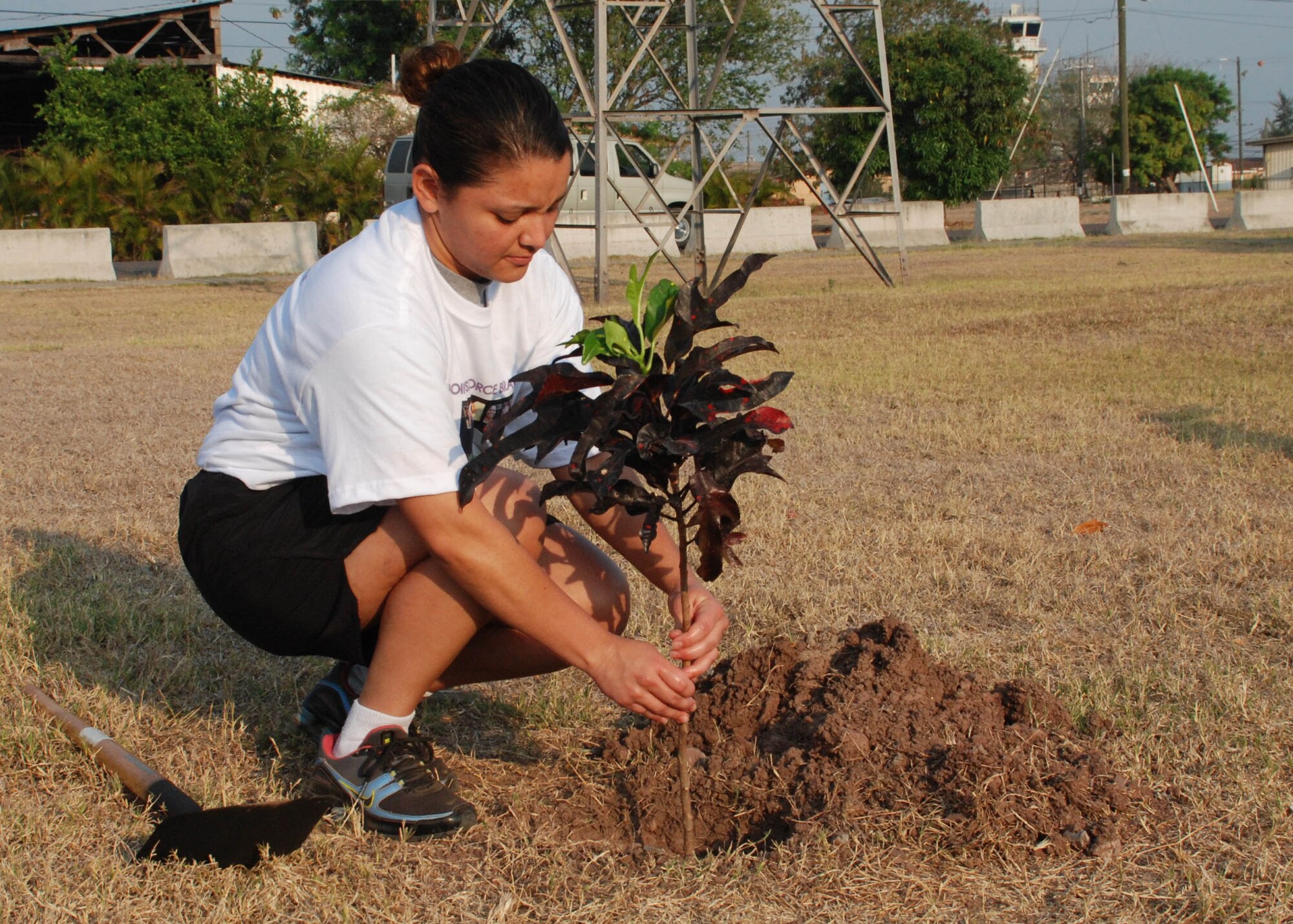 SOTO CANO AIR BASE, Honduras -- Army Sgt. Diana Guevara, Joint Task Force-Bravo's NCO of the Quarter, plants a tree in front of the Oasis to commemorate Women's History Month here March 30.  Nearly 150 members of JTF-B participated in a "Save our Planet" walk around the base as they learned about the native trees here and picked up trash.  (U.S. Air Force photo/Tech. Sgt. Rebecca Danét)