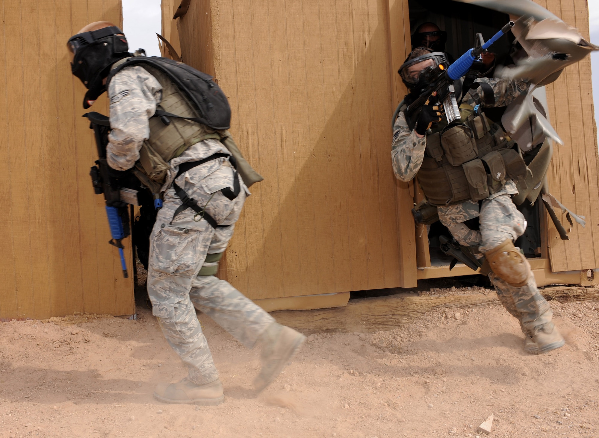 CANNON AIR FORCE BASE, N.M. -- Two security forces Airmen exit a cleared building while securing a "village" during training March 20 in Roswell, N.M. Two six-man teams worked together to take a mock village in the culmination of a week-long training event. (U.S. Air Force photo/Airman 1st Class Evelyn Chavez)