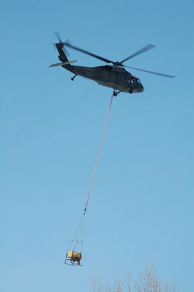 Black Hawk helicopter carrys massive one-ton sandbag en route to placement.  North Dakota National Guardsmen work on flood duty to combat the rising Red River in Fargo, North Dakota. Over 3,000 soldiers and airmen from North Dakota and surrounding states work together to keep the state safe. 
