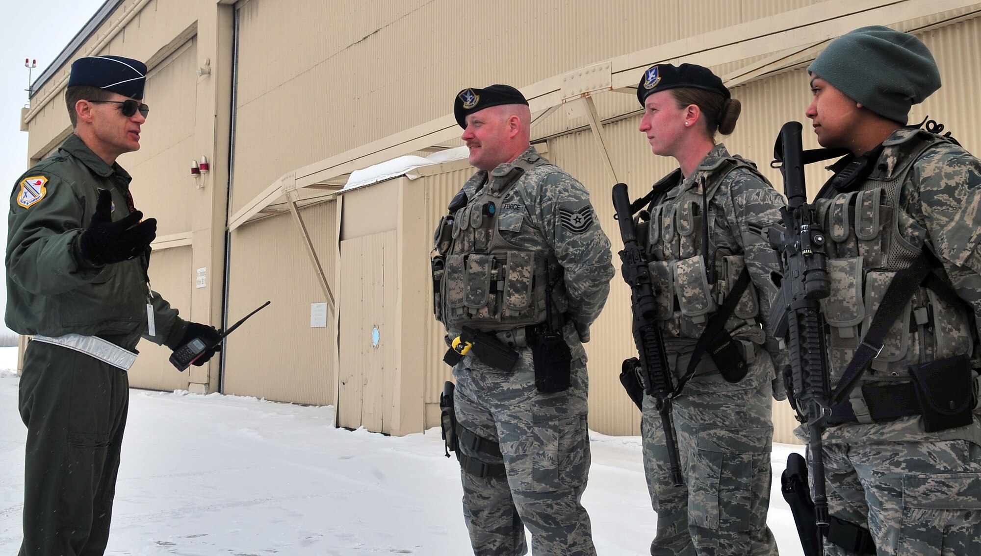 Brig. Gen. Mark W. Graper, 354th Fighter Wing commander, visits Tech. Sgt. Nathan Harbour, Airman 1st Class Danna Miles, and Airman 1st Class Elvira Godley, March 27, 2009, Eielson Air Force Base, Alaska. The Airmen, assigned to 354th Security Forces Squadron, were manning one of the entry control points necessary due to relocation of aircraft to Eielson AFB because of Mount Redoubt's eruptions. (U.S. Air Force photo/ Airman 1st Class Willard E. Grande II)