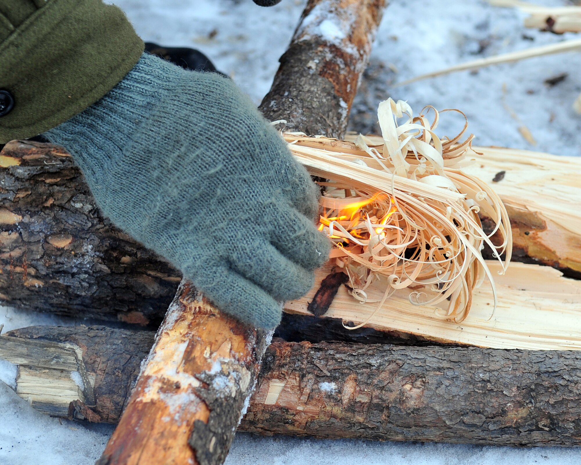 Airman 1st Class Chris Oglevie, Arctic Survival School instructor, Detachment 1, 66th Training Squadron, ignites feather sticks during a demonstration March 26, 2009, Eielson Air Force Base, Alaska. Feather sticks are an efficient way to start a fire in a wet arctic climate. (U.S. Air Force photo/Airman 1st Class Willard E. Grande II)