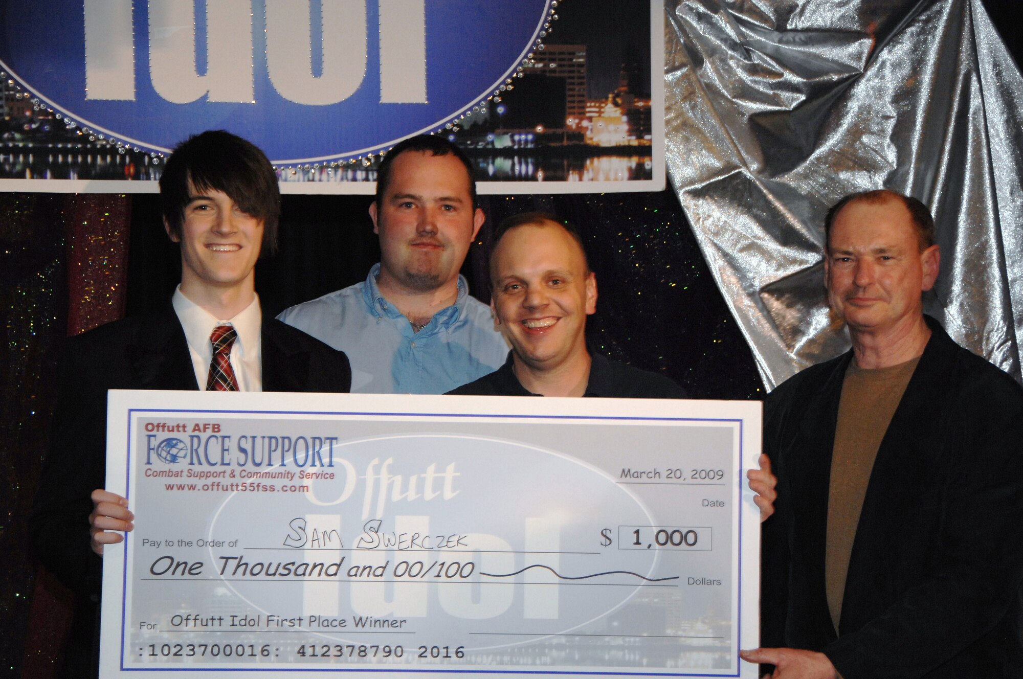 OFFUTT AIR FORCE BASE, Neb. -- Sam Swerczek accepts his one thousand dollar check after winning the 2009 Offutt Idol competition at the Patriot Club March 20. Sam who performs regularly with "The Young Americans," a singing and dancing group, said he was thrilled with the victory.
Air Force Photo by Dana P. Heard