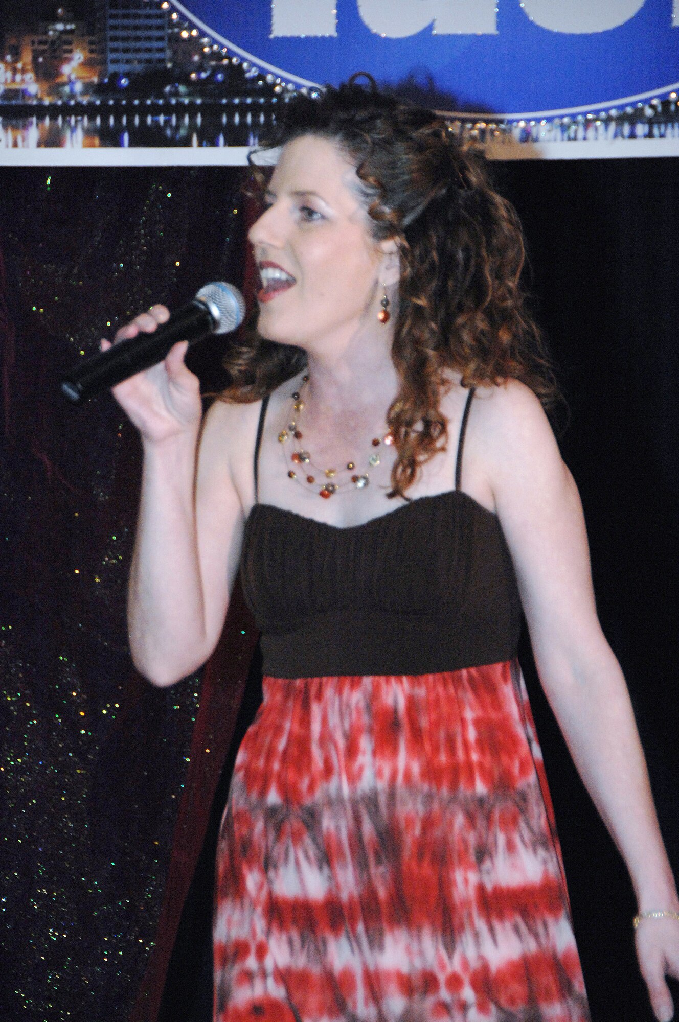 OFFUTT AIR FORCE BASE, Neb. -- Mrs. Judy Frison performs at the Patriot Club March 20, during the finals of 2009 Offutt Idol competition. Mrs. Frison who said she enjoys singing, has recently been invited to sing the "National Anthem" at a Omaha Royals baseball game.  
Air Force Photo by Dana P. Heard