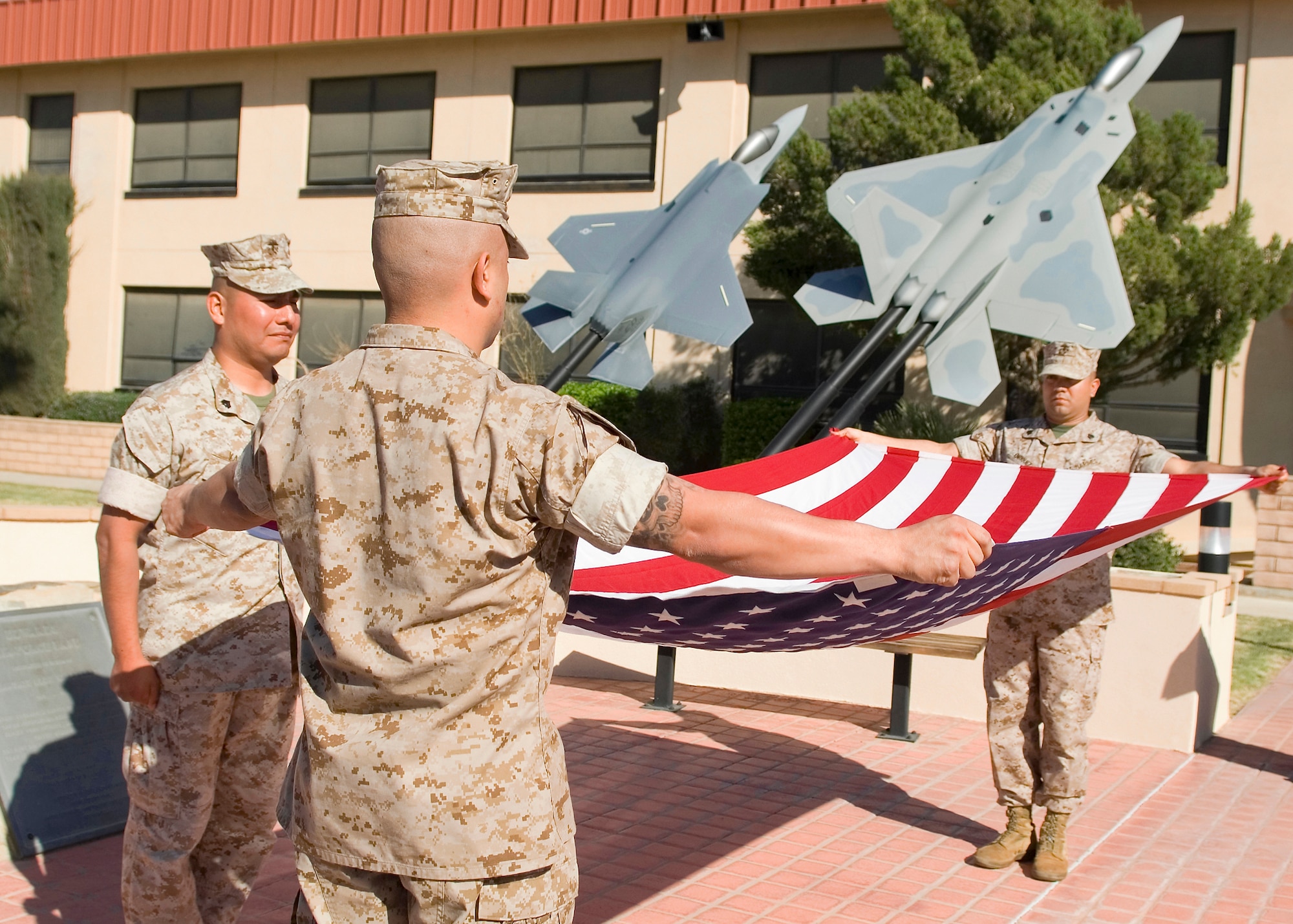 Marines assigned to Marine Aircraft Group 46 Detachment Bravo fold the flag during a retreat ceremony in front of Air Force Flight Test Center Headquarters March 26. (U.S. Air Force photo/Mike Cassidy)