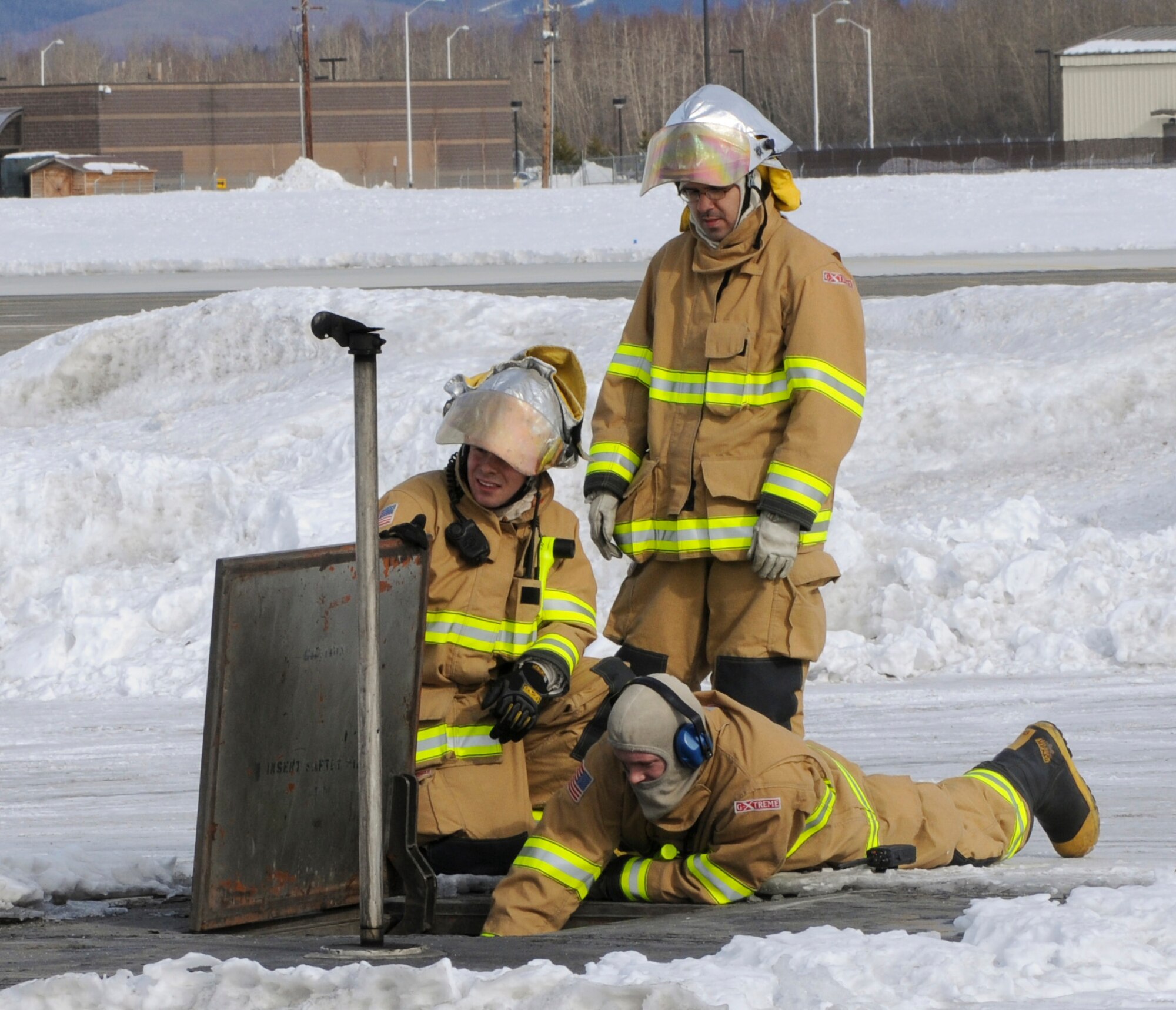 Airmen with the base fire department watch the arresting cable wind into place, March 25, 2009, Eielson Air Force Base, Alaska.  The generators that wind the cable work quickly to resume normal runway operations. (U.S. Air Force photo/Airman 1st Class Laura Max)