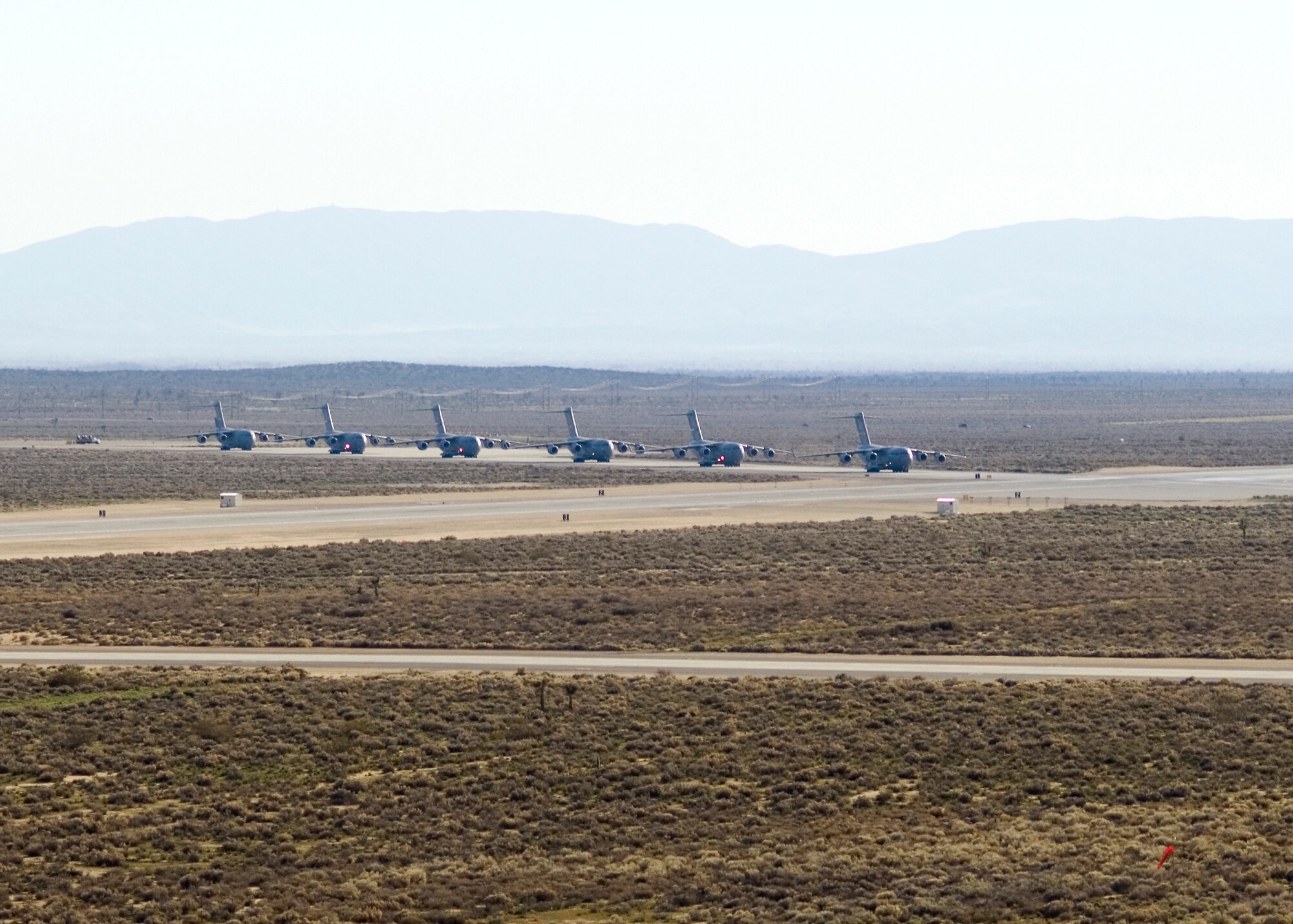 C-17 Globemaster IIIs at Edwards Air Force Base, Calif., taxi out for a six-ship formation testing mission. The C-17 is capable of rapid strategic delivery of troops and cargo to main operating bases or directly to forward bases in deployed environments. (U.S. Air Force photo/Mike Cassidy)