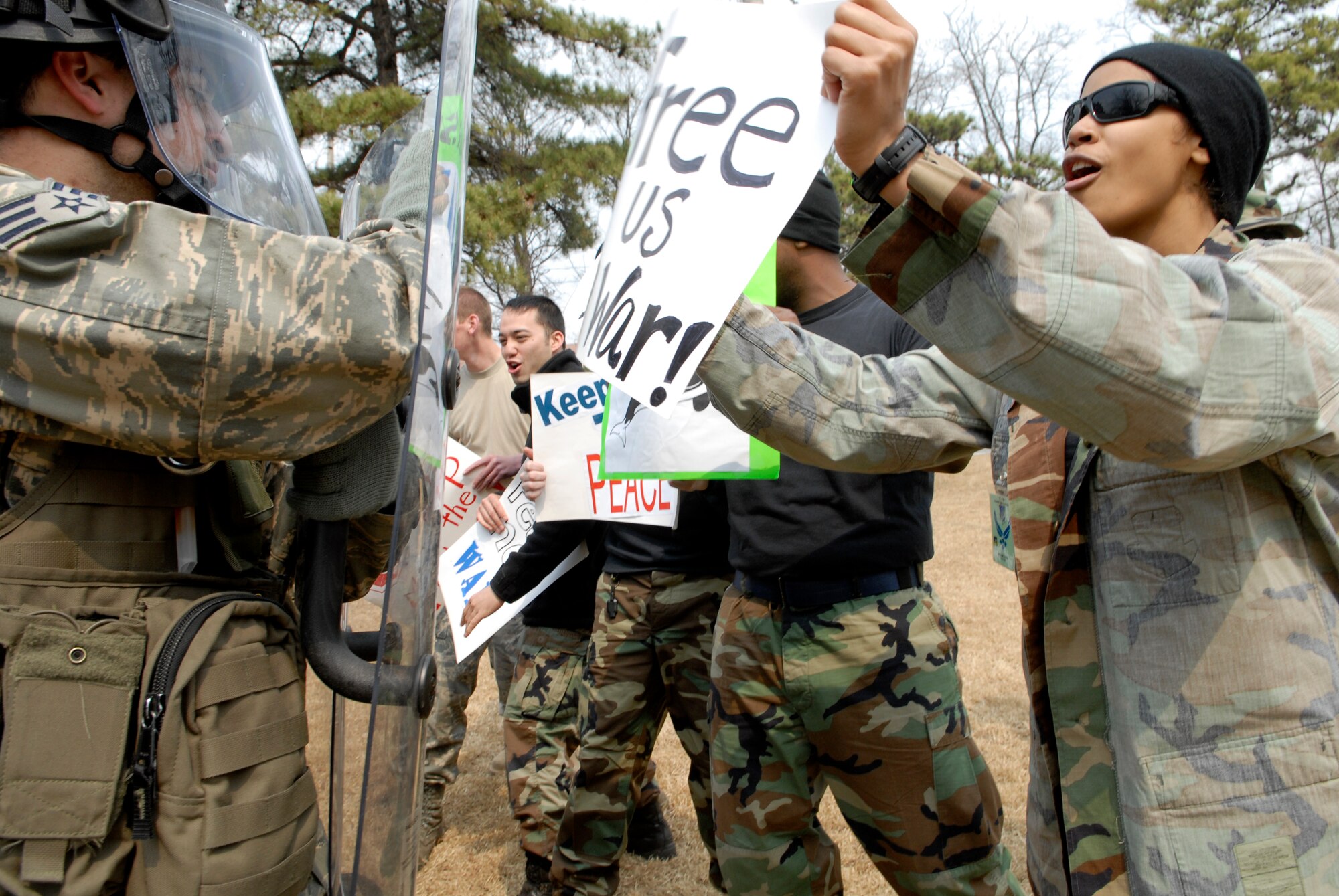 Security forces Airmen use riot gear to hold off a group of simulated protestors near the front gate of Osan Air Base, Republic of Korea March 30 during Operational Readiness Exercise Beverly Bulldog 09-02.  The pre-scheduled exercise is designed to help the 51st Fighter Wing to prepare for their Operational Readiness Inspection in April. (U.S. Air Force photo/Staff Sgt. Brian Ferguson)