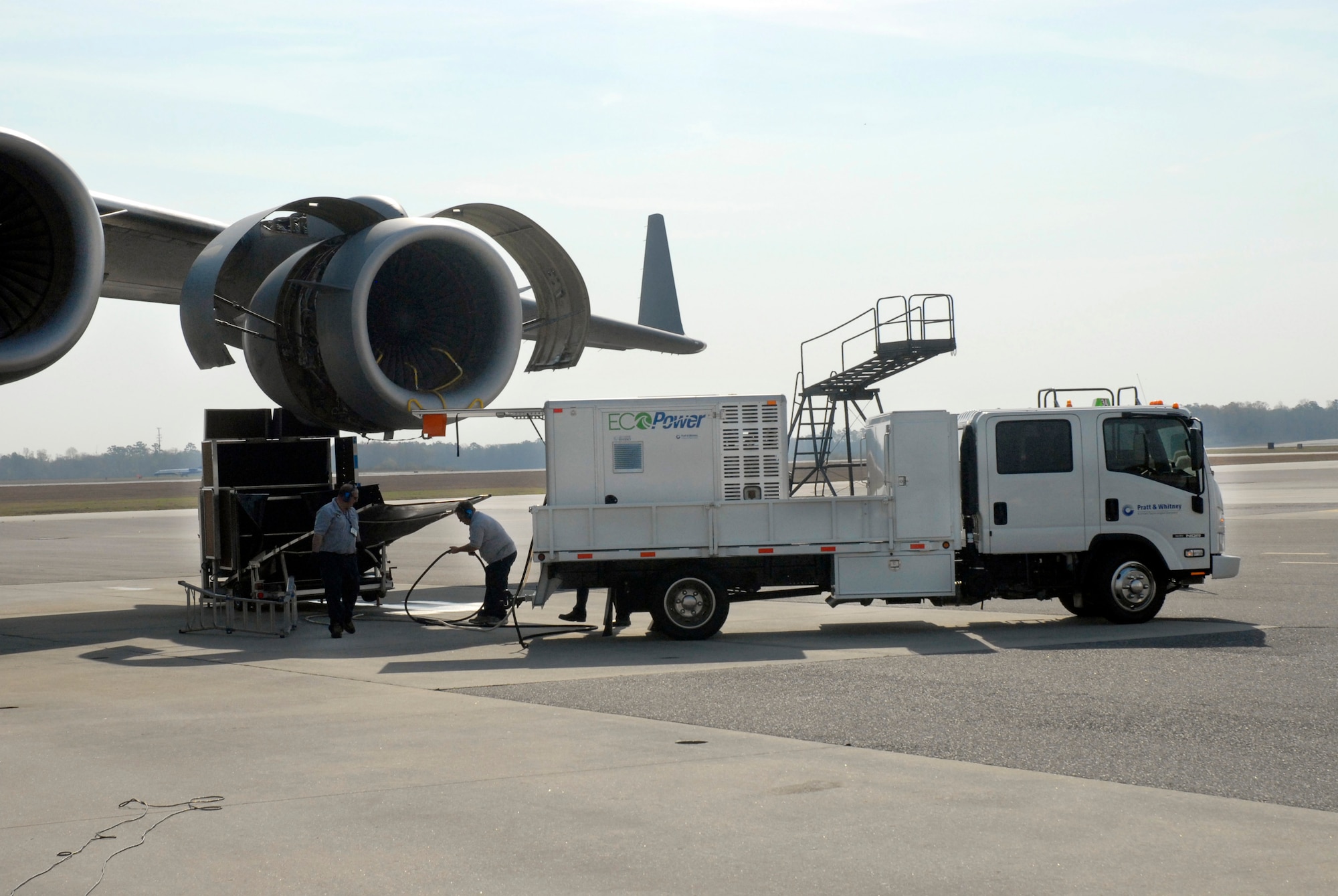 Contractors wash a C-17 Globemaster III engine with the EcoPower Engine Wash System March 12 at Charleston Air Force Base, S.C. The closed-loop system collects and recycles the runoff water, keeping potentially contaminated water off of the flightline and running off into the surrounding areas.(U.S. Air Force photo/Staff Sgt. Robert Sizelove) 
