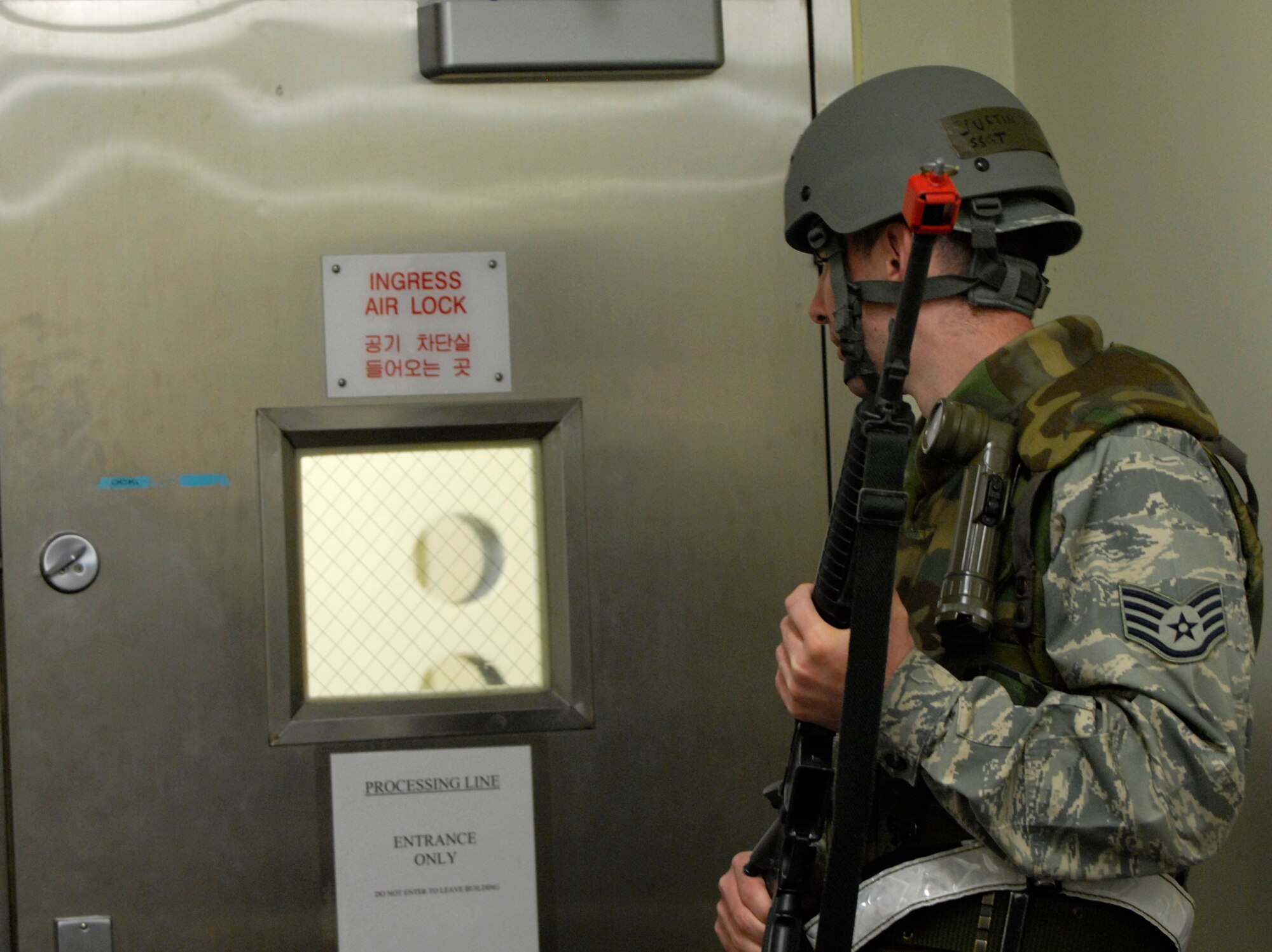 Staff Sgt. Jason Slater, 8th Operation Support Squadron, aircrew flight equipment technician performs proper door guard procedures at the Aircrew Contamination Control Area during the Peninsula-Wide Operational Readiness Exercise at Kunsan Air Base, Republic of Korea, March 30, 2009. The exercise is conducted to evaluate members of the Wolf Pack and to test their readiness and ability to perform the Wing's wartime mission. (U.S. Air Force Photo/Senior Airman Dana Hill)