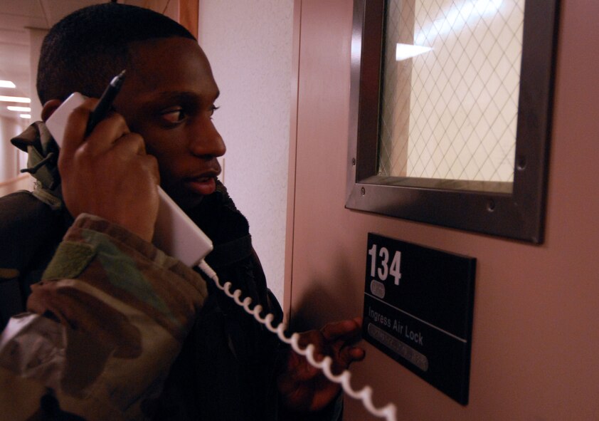 Senior Airman Nicholas Franklin, a shelter management augmentee, requests authentication from an Airman before allowing entry to a dormitory during the Peninsula Wide Readiness Exercise Beverly Bulldog 09-02 at Kunsan Air Base, Republic of Korea, March 31, 2009. The Airmen are participating in the Beverly Bulldog exercise one last time before the Operational Readiness Inspection. Airman Franklin is a lodging front desk clerk at the Seaside Inn assigned to the 8th Force Support Squadron. (U.S. Air Force Photo/Senior Airman Gustavo Gonzalez)
