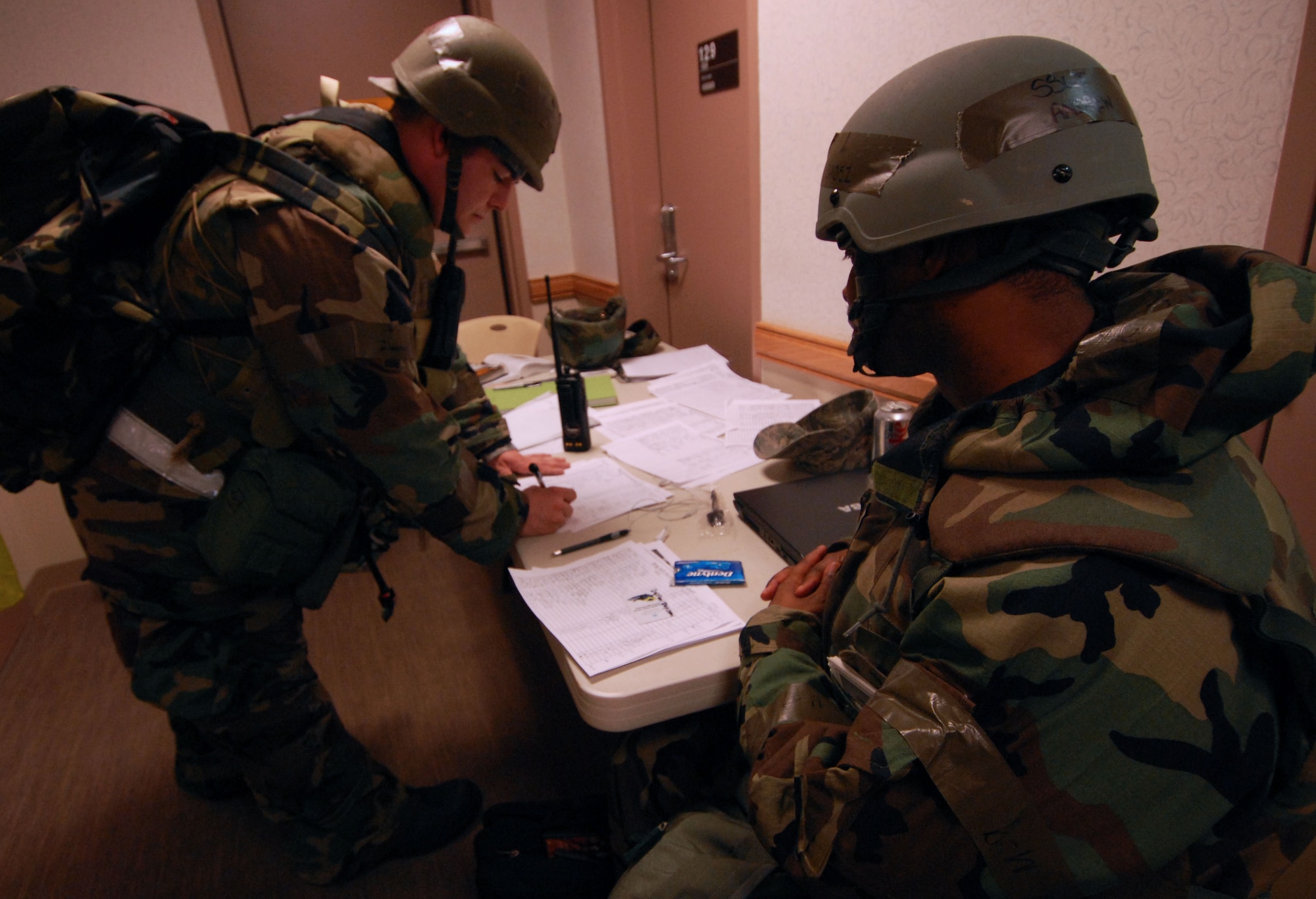 Staff Sergeant Andrew Stevens, a shelter management augmentee, ensures Senior Airman Daniel Blair, 8th Civil Engineer Squadron, signs in at the entry control point after entering a dormitory during the Peninsula Wide Readiness Exercise Beverly Bulldog at Kunsan Air Base, Republic of Korea, March 31, 2009. The Airmen are participating in the Beverly Bulldog exercise one last time before the Operational Readiness Inspection. Sergeant Stevens is a knowledge Operator for the 8th Mission Support Squadron. (U.S. Air Force Photo/Senior Airman Gustavo Gonzalez)