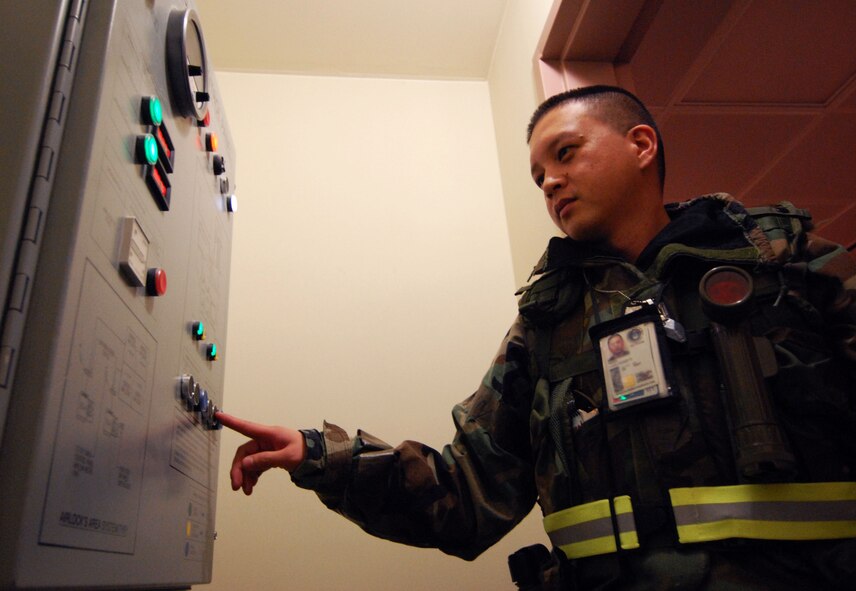 Technical Sgt. A.J. Isidro, 8th Civil Engineer Squadron, unlocks the door at a dormitory entry control point during the Peninsula Wide Readiness Exercise Beverly Bulldog 09-02 at Kunsan Air Base, Republic of Korea, March 31, 2009. The Airmen are participating in the Beverly Bulldog exercise one last time before the Operational Readiness Inspection. Sergeant Isidro is a dorm manager for building 603. (U.S. Air Force Photo/Senior Airman Gustavo Gonzalez)