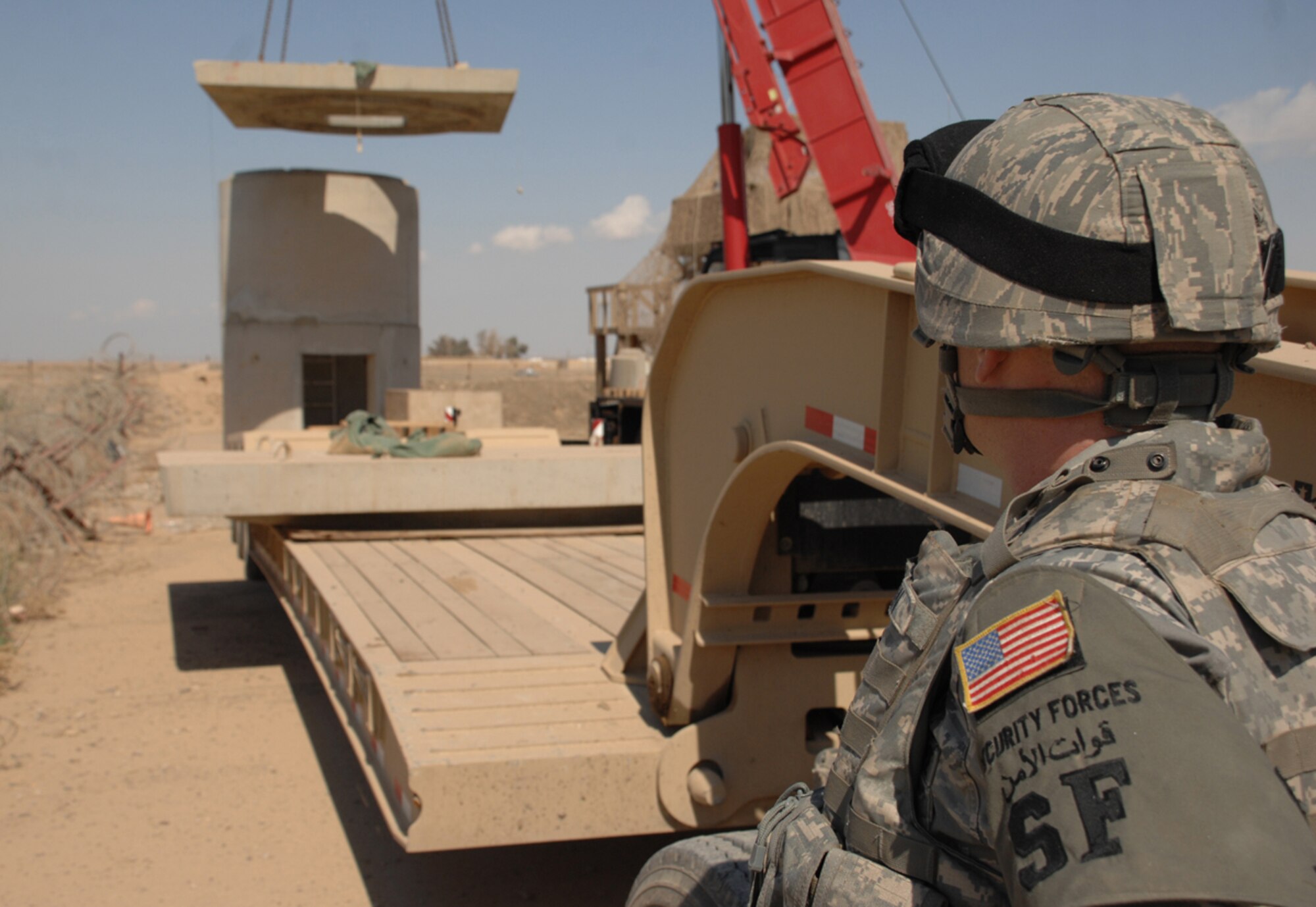 Tech. Sgt. Shawn Quinn, 506th Expeditionary Security Forces Squadron, deployed from Westover Air Reserve Base, Mass., watches the disassembly of a concrete tower at Kirkuk Regional Air Base, Iraq, March 17, 2009. The Springfield, Mass., native, and other security forces and civil engineering Airmen are reusing pieces from these structures in a self-help project to build guard towers with increased fortification. (U.S. Air Force Photo/Senior Airman Jessica Lockoski)