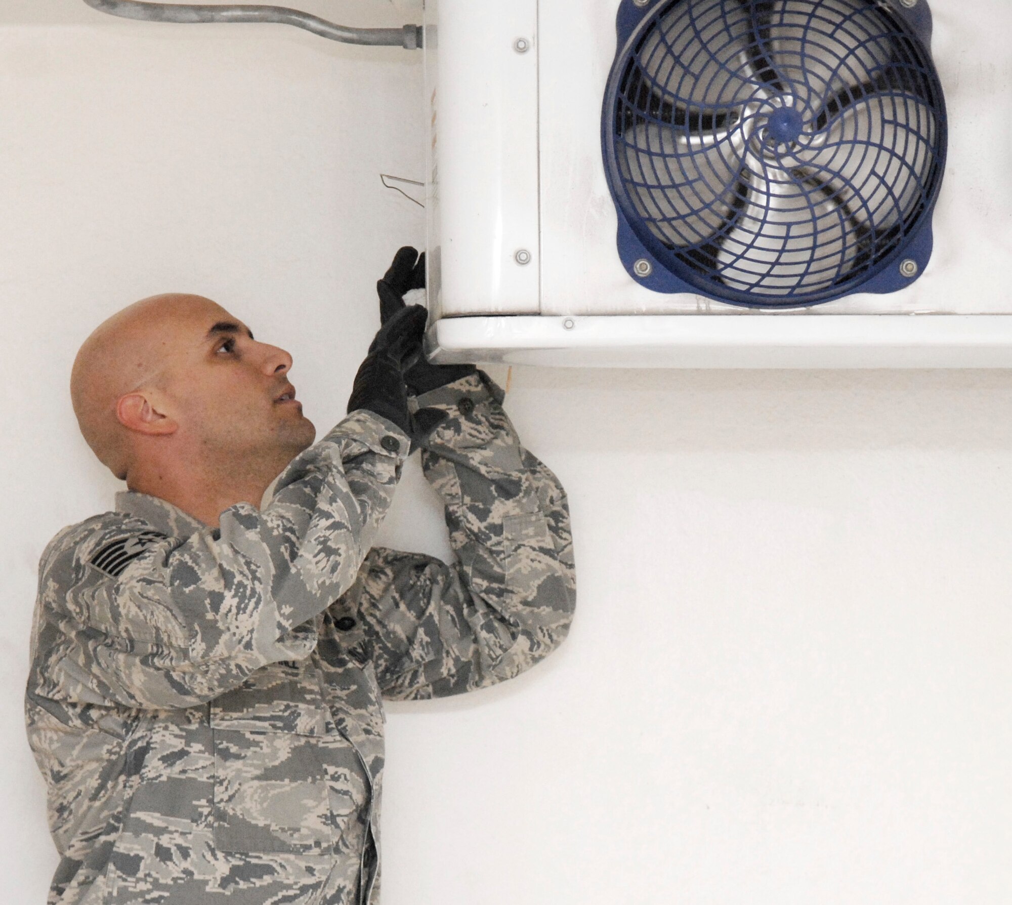 Technical Sgt. Gabriel Martinez checks the temperature in a refrigeration unit used for holding remains of fallen warriors March 26 at an air base in Southwest Asia. Sergeant Martinez is the 379th Expeditionary Force Support Squadron NCO in charge of mortuary affairs. (U.S. Air Force photo/Senior Airman Andrew Satran) 
