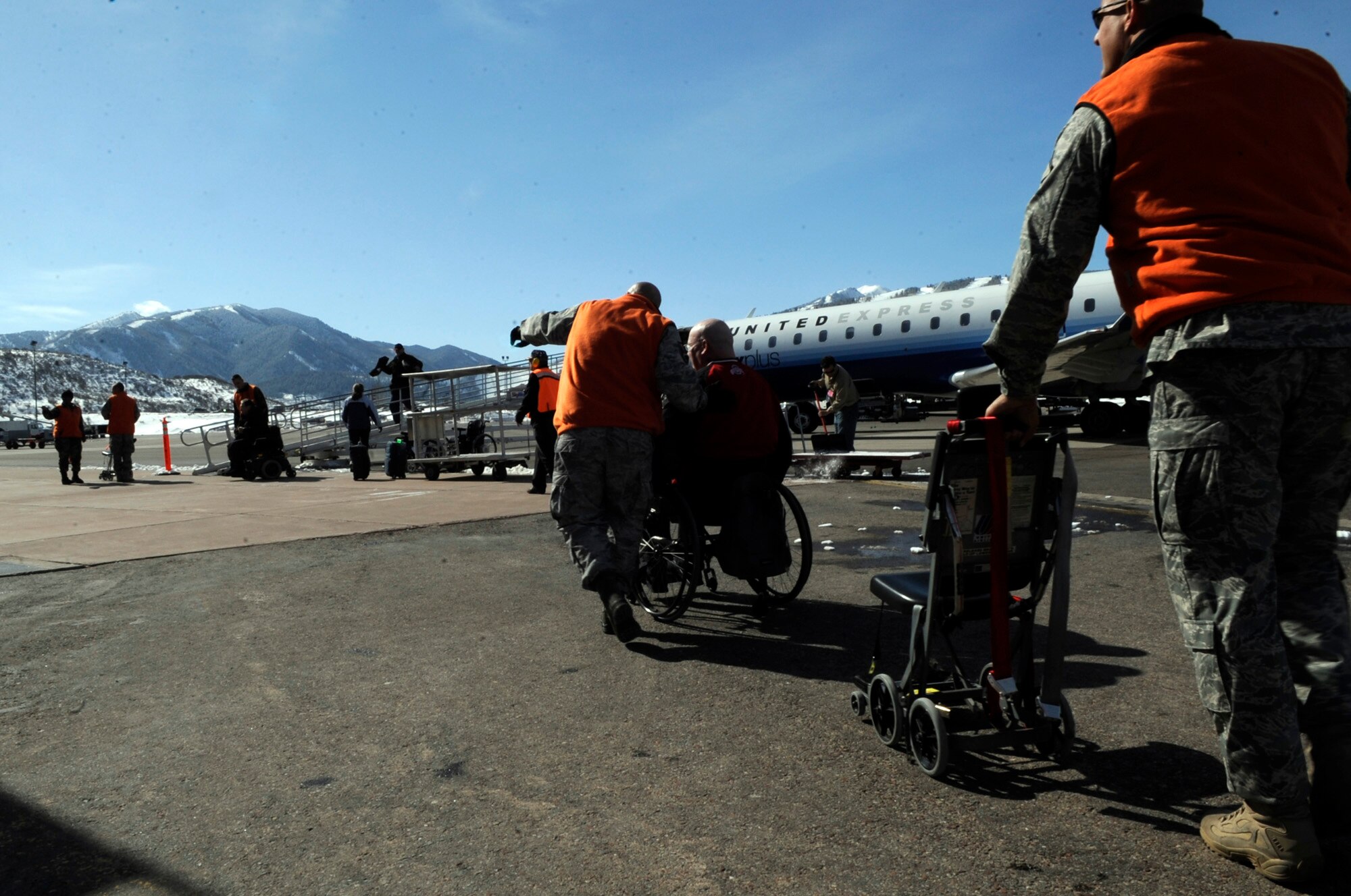 Airmen from Luke Air Force Base, Ariz. escort a veteran off a United aircraft March 28 at the Aspen Airport, Colo. Veterans from all over the world fly into Aspen to attend the Disabled American Veterans Winter Sports Clinic. (U.S. Air Force photo/Staff Sgt. Desiree N. Palacios)

