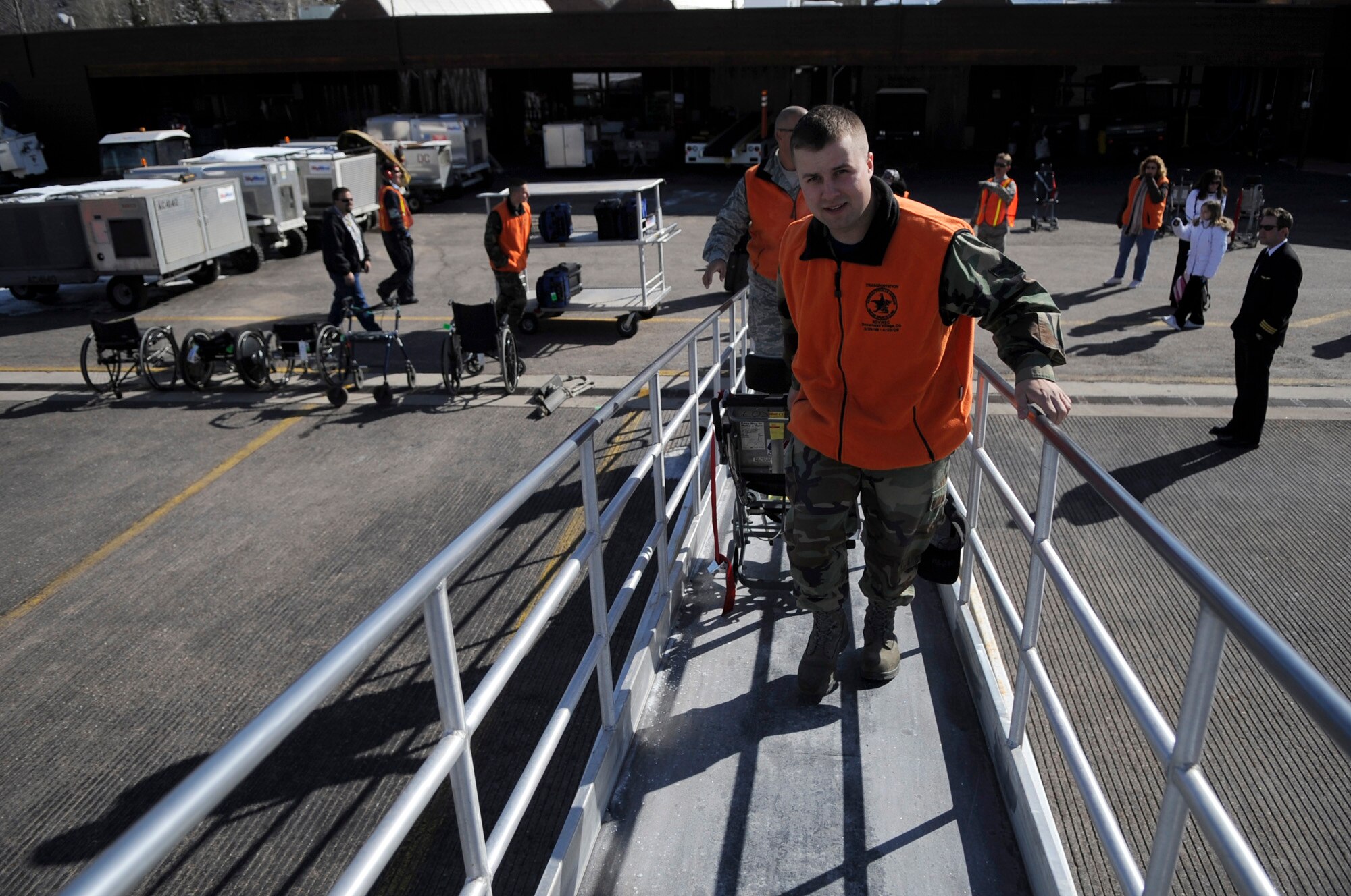 Airman 1st Class David Hague works his way up the ramp of a United aircraft to escort veterans off the aircraft March 28 at the Aspen Airport, Colo. Airman Hague is an aerospace propulsion journeyman assigned to the 56th Component Maintanance Squadron at Luke Air Force Base, Ariz. Veterans from all over the world fly into Aspen to attend the Disabled American Veterans Winter Sports Clinic. (U.S. Air Force photo/Staff Sgt. Desiree N. Palacios)

