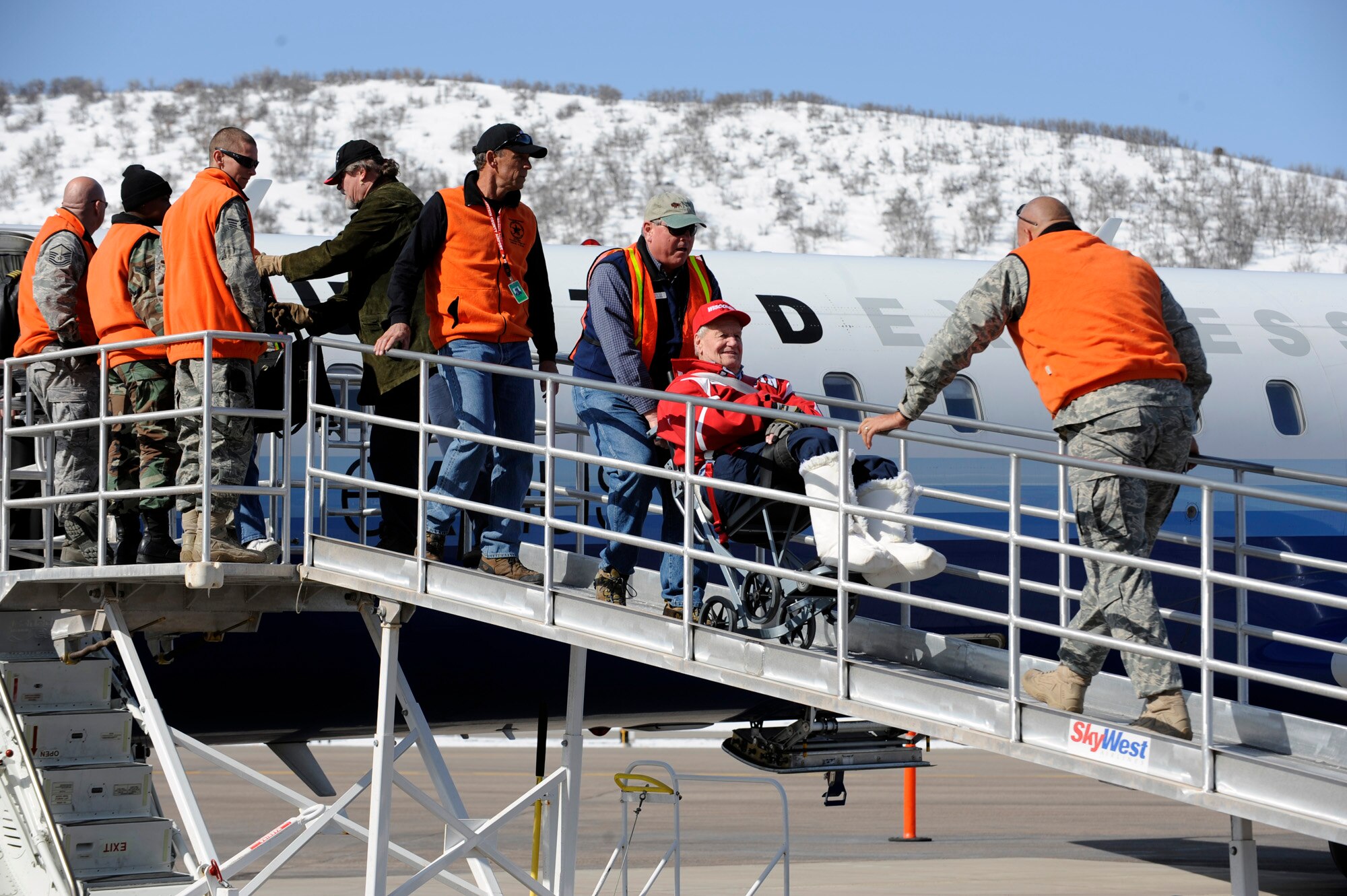 Steve Slater escorts Russell Worth off an United Aircraft March 28 at the Aspen Airport, Colo. Mr. Slater is a ski instructor for the Disabled American Veterans Winter Sports Clinic, and Mr. Fleuker is from Watertown, Wisc. This is Worth's 16th year attending the Disabled American Veterans Winter Sports Clinic. (U.S. Air Force photo/Staff Sgt. Desiree N. Palacios)

