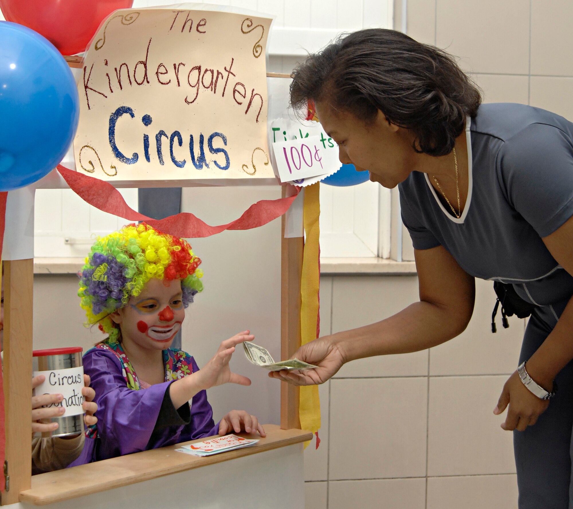 Londyn Wilson, daughter of Angela and Chance Wilson, Incirlik Unit School teachers, takes a donation from Linda Watts, Wife of Master Sgt. Kordell Watts, before performing in the kindergarten circus at the IUS, Friday, March 27, 2009. The children helped design the set, props and costumes, as well as writing the script for the circus they put on for their parents. The whole experience incorporated learning about animals along with math and writing, said Harry Atkinson, IUS kindergarten teacher. (U.S. Air Force photo/Senior Airman Benjamin Wilson, 39th Air Base Wing Public Affairs)