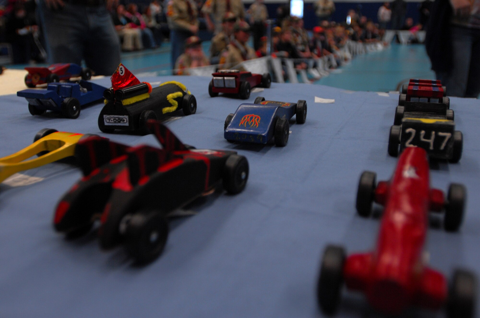 Derby cars sit on display before races start, during a Cub Scout District Level Pinewood Derby contest, March 19, 2009 at the Ramstein High School gym. The pinewood derby encourages scouts to learn and improve on their craftsmanship and practice good sportsmanship. (U.S. Air Force photo by Airman 1st Class Kenny Holston)