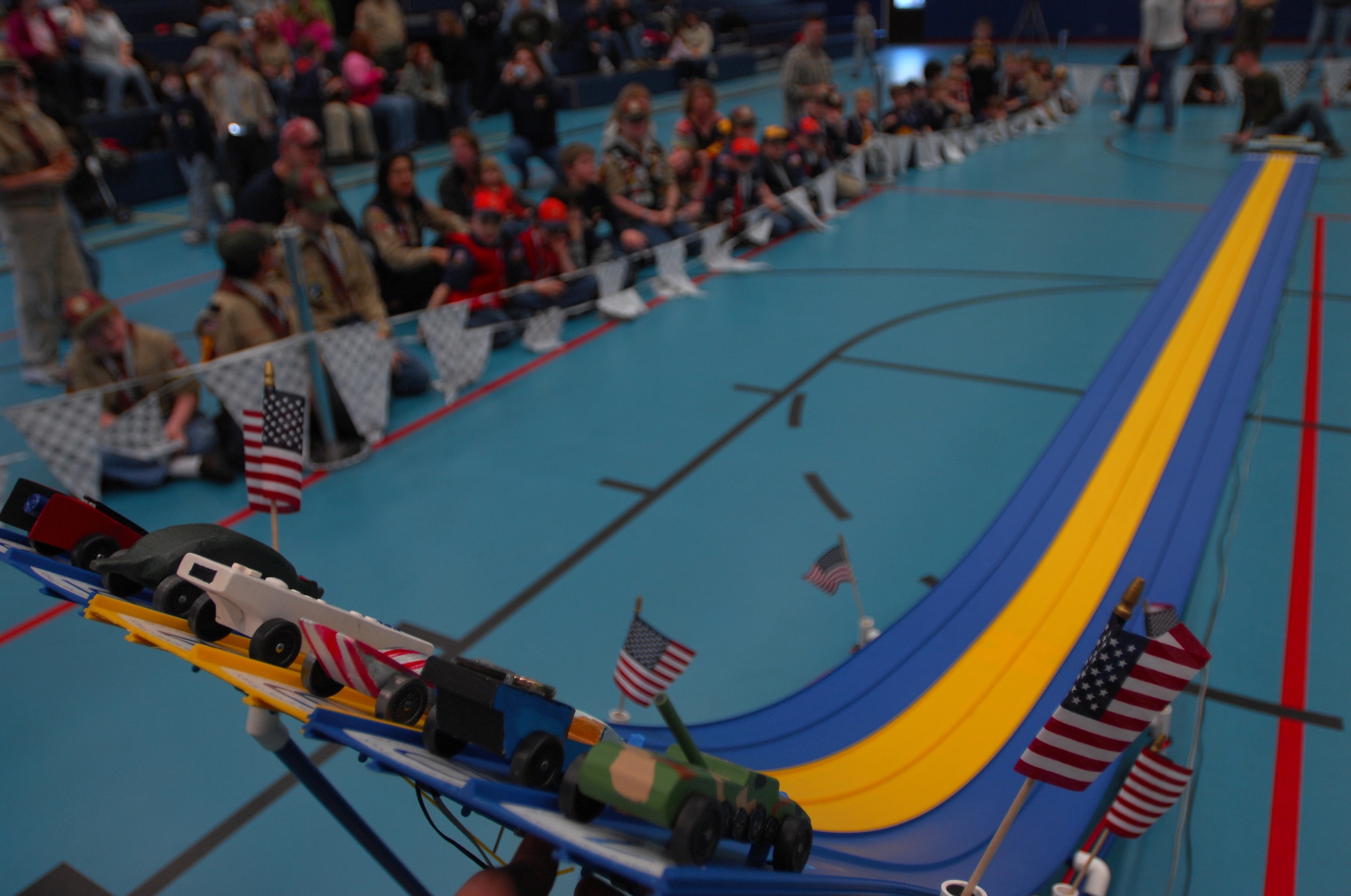 Derby cars are held at the starting line as cub scouts anticipate the first race, during a Cub Scout District Level Pinewood Derby contest, March 19, 2009 at the Ramstein High School gym. The pinewood derby encourages scouts to learn and improve on their craftsmanship and practice good sportsmanship. (U.S. Air Force photo by Airman 1st Class Kenny Holston)