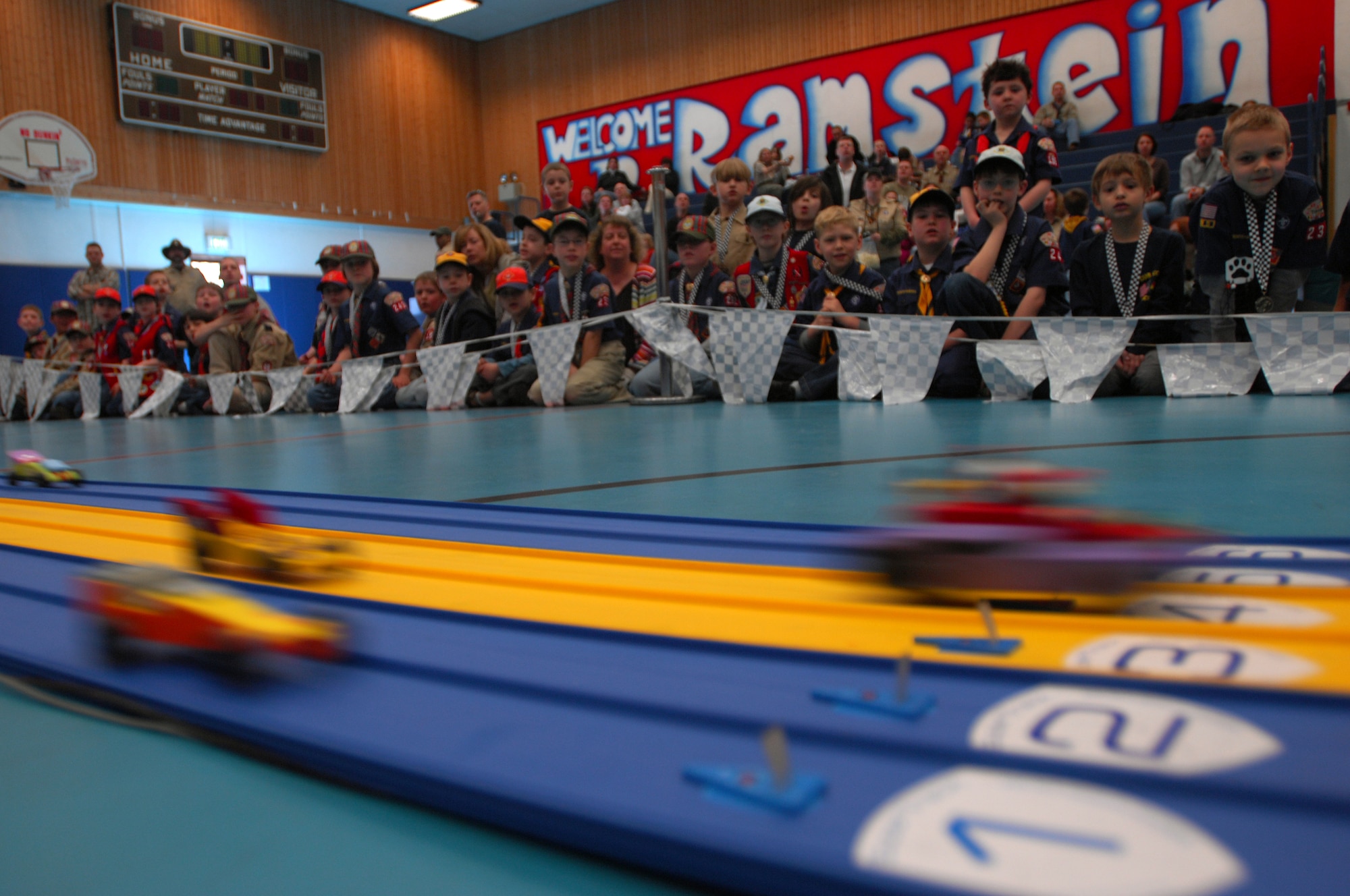 Derby cars streak across the track during a Cub Scout District Level Pinewood Derby contest, March 19, 2009 at the Ramstein High School gym. The pinewood derby encourages scouts to learn and improve on their craftsmanship and practice good sportsmanship. (U.S. Air Force photo by Airman 1st Class Kenny Holston)
