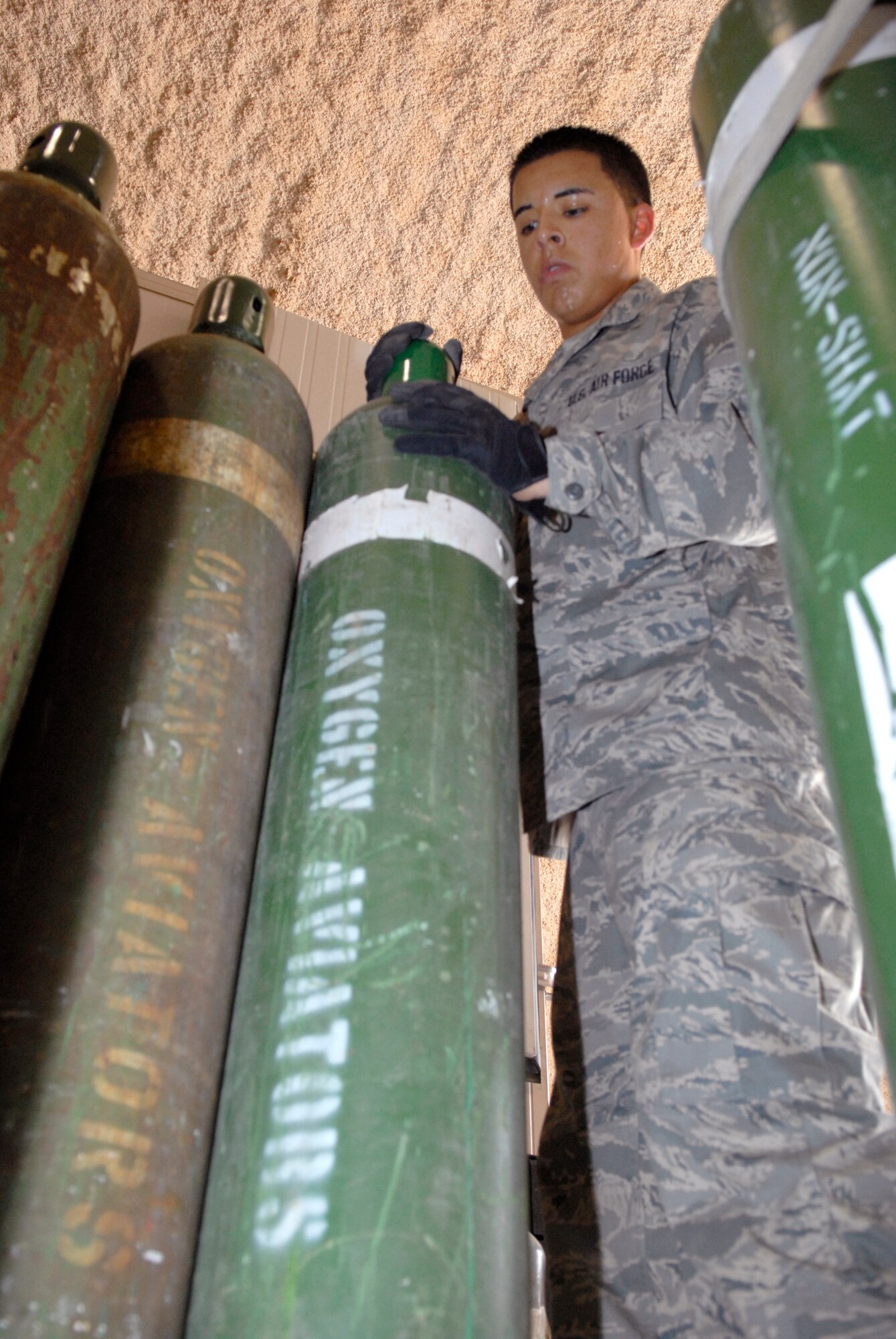Airman 1st Class Christopher Ramos, a 379th Expeditionary Logistics Readiness Squadron hazmat pharmacy journeyman, delivers tanks of oxygen for aircraft maintainers, Mar. 29, 2009, at an undisclosed location in Southwest Asia.  The Hazmat Pharmacy supplies Balad and Sather Air Bases, Iraq, along with local units with oxygen, nitrogen and other materials for mission sustainment.  The pharmacy also supplies this base with engine oil and lubrication for all assigned aircraft.  Airman Ramos hails from Orange County, Calif. and is deployed from Altus Air Force Base, Okla. in support of Operations Iraqi and Enduring Freedom and Combined Joint Task Force - Horn of Africa.  (U.S. Air Force photo/Senior Airman Andrew Satran/released)   