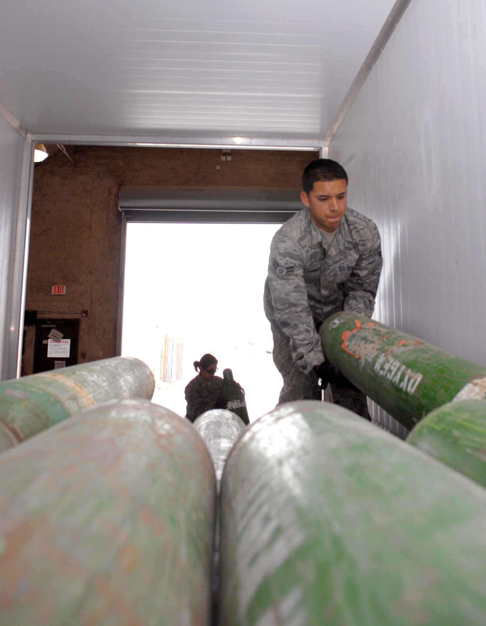 Airman 1st Class Christopher Ramos, a 379th Expeditionary Logistics Readiness Squadron hazmat pharmacy journeyman, unloads tanks of oxygen for aircraft maintainers, Mar. 29, 2009, at an undisclosed location in Southwest Asia.  The Hazmat Pharmacy supplies Balad and Sather Air Bases, Iraq, along with local units with oxygen, nitrogen and other materials for mission sustainment.  The pharmacy also supplies this base with engine oil and lubrication for all assigned aircraft.  Airman Ramos hails from Orange County, Calif. and is deployed from Altus Air Force Base, Okla. in support of Operations Iraqi and Enduring Freedom and Combined Joint Task Force - Horn of Africa.  (U.S. Air Force photo/Senior Airman Andrew Satran/released)   