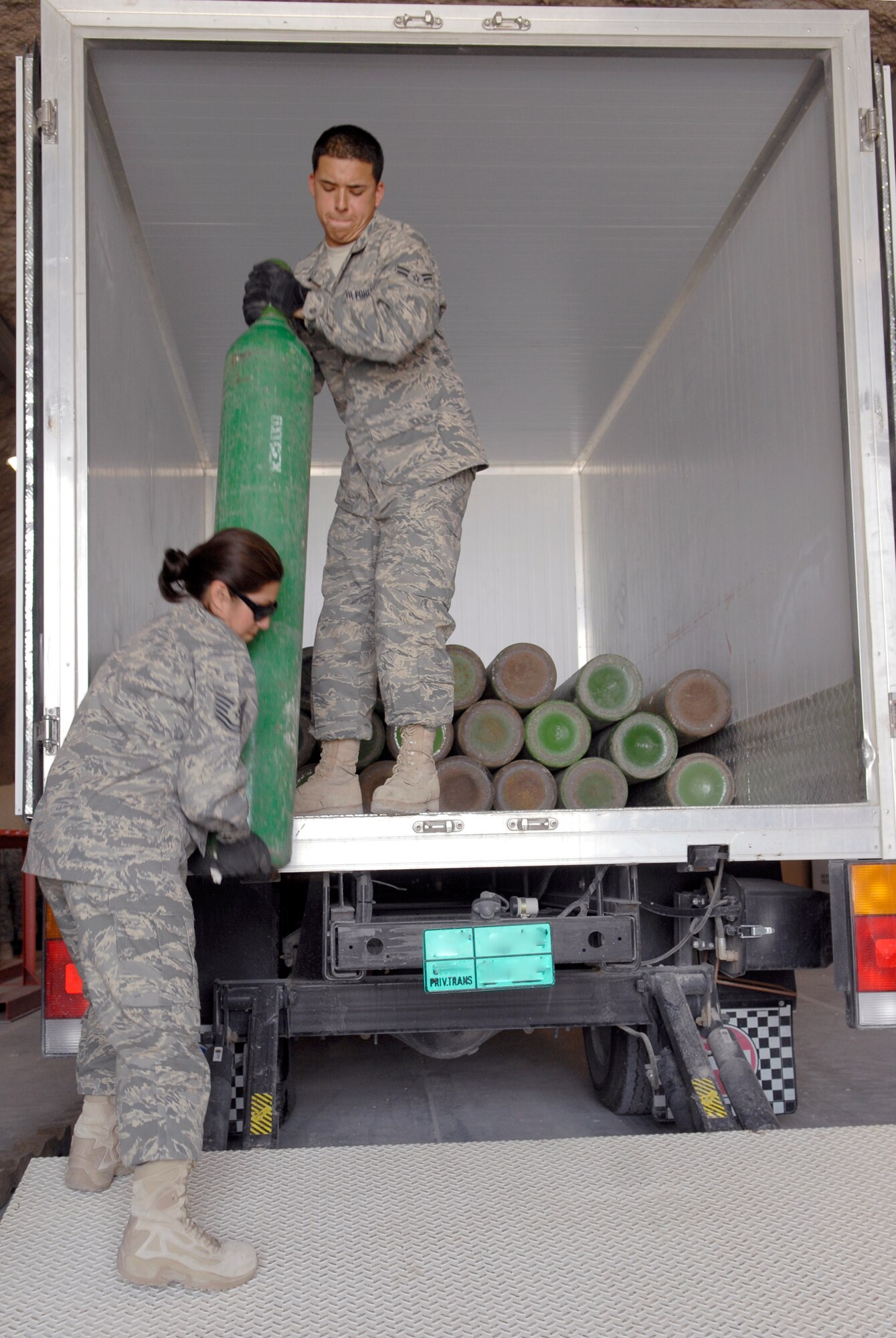 Tech. Sgt. Rebecca Gonzales, 379th Expeditionary Logistics Readiness Squadron (ELRS) NCO in charge Hazmat Pharmacy and Airman 1st Class Christopher Ramos, a 379th ELRS hazmat pharmacy journeyman, unload a shipment of oxygen tanks to be distributed throughout the base and the U.S. Central Command's Area of Responsibility, Mar. 29, 2009, at an undisclosed location in Southwest Asia.  The Hazmat Pharmacy is responsible for liquid oxygen, nitrogen, corrosive liquids, flammables, and other chemicals used by forces throughout the U.S. Central Command's Area of Responsibility.  Sergeant Gonzales hails from San Antonio, Texas and is deployed from the 149th Air National Guard Base Lackland, Texas.  Airman Ramos hails from Orange County, Calif. and is deployed from Altus Air Force, Okla.  Both are deployed in support of Operations Iraqi and Enduring Freedom and Combined Joint Task Force - Horn of Africa.  (U.S. Air Force photo/Senior Airman Andrew Satran/released)    