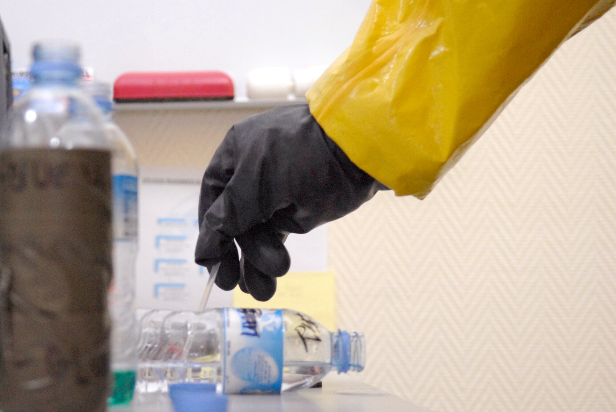 Staff Sgt. Trevor Fettig, a 379th Civil Engineer Squadron Emergency Management Journeyman, collects a liquid sample for contamination analysis during a unit exercise, Mar. 27, 2009, at an undisclosed location in Southwest Asia.  Sergeant Fettig is labeled the 'dirty man' for handling the contaminated items during the check to help prevent cross contamination with other team members.  Sergeant Fettig hails from Lompoc, Calif. and is deployed from Travis Air Force Base, Calif. in support of Operations Iraqi and Enduring Freedom and Combined Joint Task Force - Horn of Africa.  (U.S. Air Force photo/Senior Airman Andrew Satran/released)