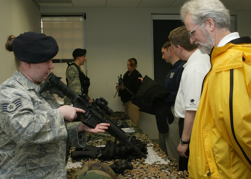 Dobbins Air Reserve Base, Ga. - Staff Sgts.  Jennifer Dawley and Richard Potter, 94th Security Forces Squadron response force members, give members of the 2009 Honorary Commanders Association (HCA) an up close and personal look at the weapons used by security forces for base security during a tour on March 24.  The HCA is a cooperative effort of the Cobb Chamber of Commerce, Dobbins Air Reserve Base and Naval Air Station Atlanta (NAS).  Civilian business, government service employees and educators are paired with commanders and senior officers of military units stationed at Dobbins and NAS.  (U.S. Air Force photo/Don Peek)