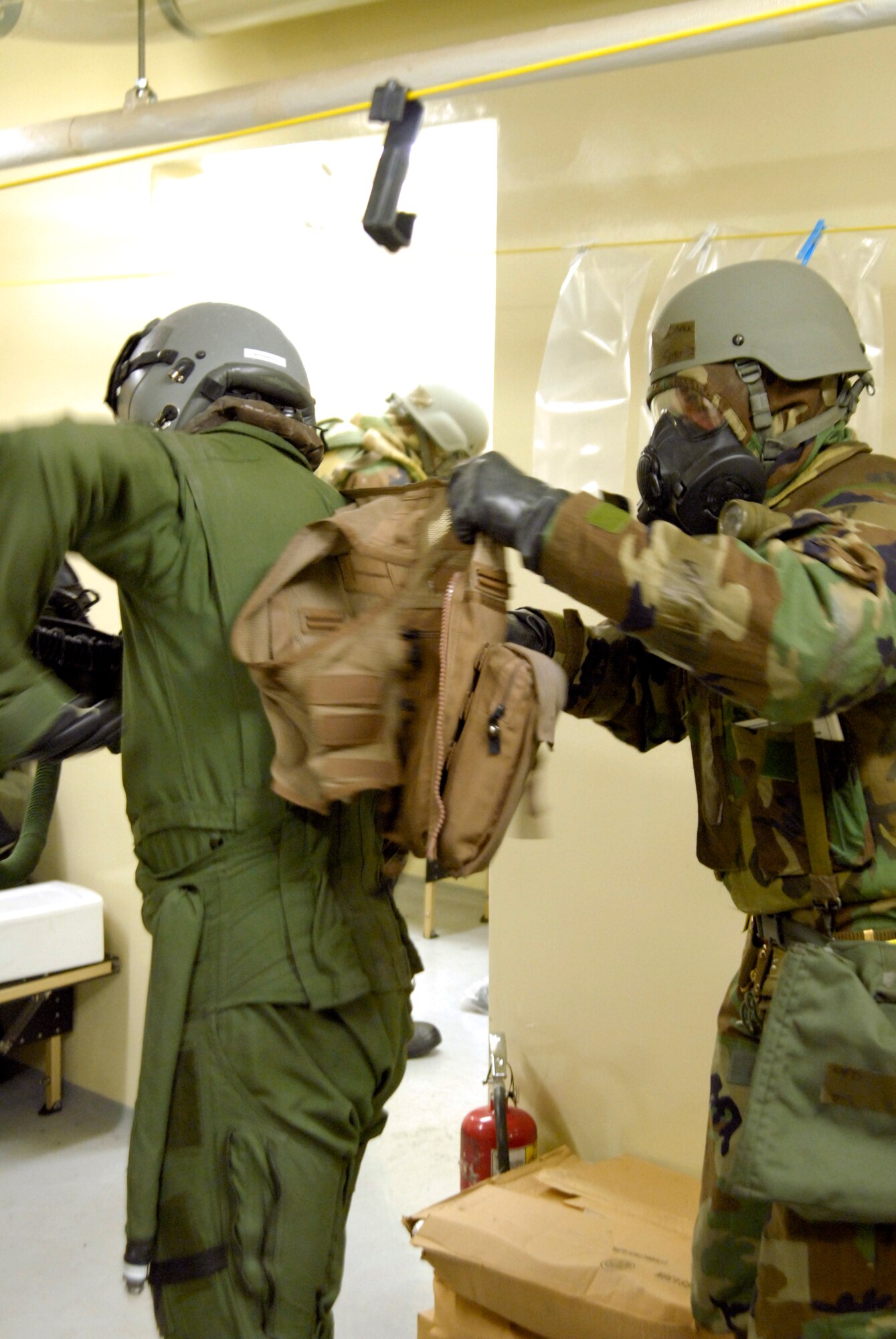Senior Airman Stephen Slack, 35th Fighter Squadron aircrew flight equipment technician, removes a piece of potentially decontaminated equipment from 1st Lt. Brad Zimmerman, 80th Fighter Squadron, at Kunsan Air Base, Republic of Korea, March 30, 2009. The Airmen are currently participating in Beverly Bulldog 09-02, the last Peninsula-wide Operational Readiness Exercise before the 8th Fighter Wing's Operational Readiness Inspection of the 8th Fighter Wing. (U.S. Air Force Photo by Staff Sgt. Jason Colbert)

