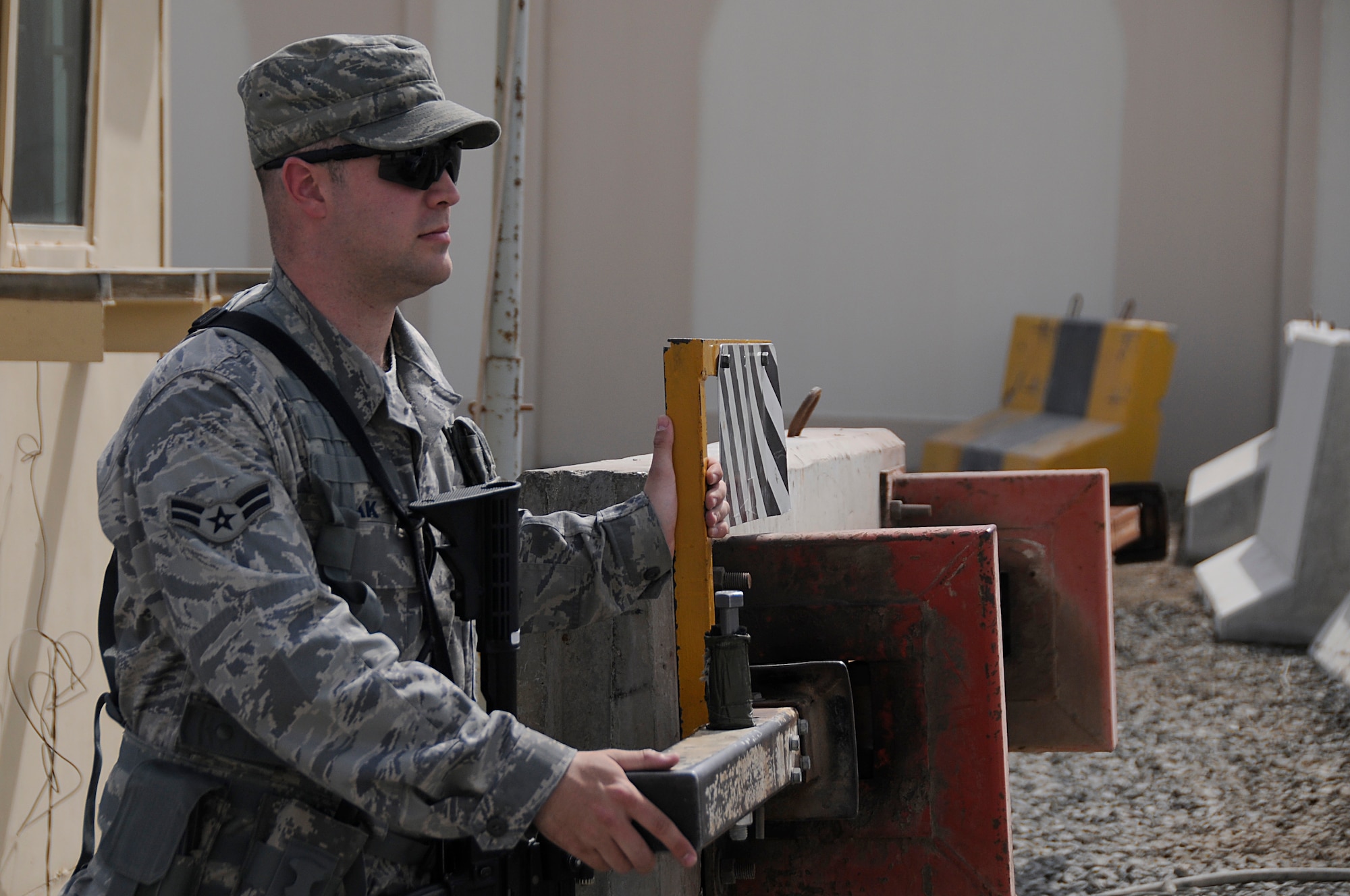 SOUTHWEST ASIA - Airman 1st Class Ryan Reak, 380th Expeditionary Security Forces Squadron, entry controller opens a gate for a vehicle to pass, Mar 21. Security Forces members man gates at critical areas ensuring no unauthorized people enter, keeping the areas safe for other Airman to complete their mission. Airman Reak is deployed from the 96th Security Forces Squadron, Eglin AFB, Fla. and hails from Pensacola, Fla. (U.S. Air Force photo by Senior Airman Brian J. Ellis) (Released)