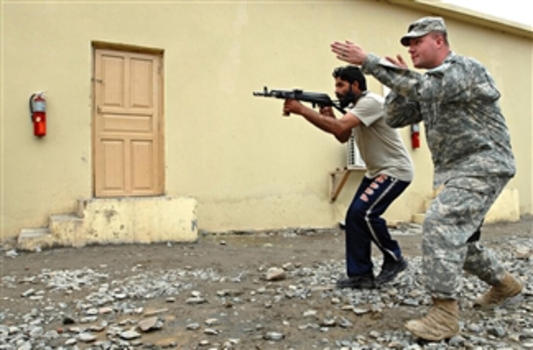 U.S. Army Spc. W. Eric Mraz, 3rd Platoon, 527th Military Police Company, shows an Afghan National Police officer how to walk with a drawn weapon as part of the Special Tactics and Training course at Forward Operating Base Bostick, in Nari, Konar, Afghanistan, on March 21, 2009.  The program is developing a local SWAT-style team called the Special Tactics Team for the Afghan National Police station in Nari.  