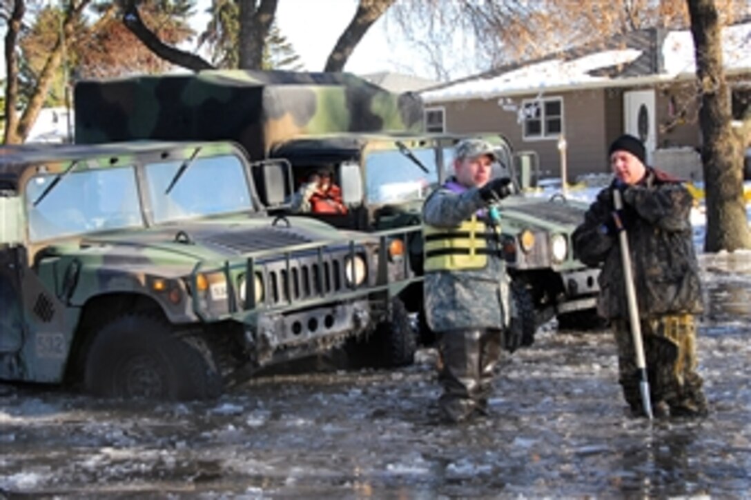 U.S. Army Staff Sgt. Robin Mattson speaks with a resident while patrolling in Moorhead, Minn., March 28, 2009. About 500 members of the Minnesota National Guard continue to provide assistance to civil authorities to support flood-fighting efforts.