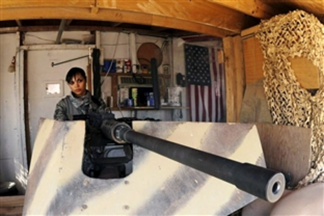 U.S. Air Force Senior Airman Elizabeth Gonzalez looks over the flightline on Sather Air Base, Iraq, with a .50 caliber machine gun, March 26, 2009. Gonzalez, one of a few security forces members qualified on the .50 caliber machine gun, is assigned to the 447th Expeditionary Security Forces Squadron.