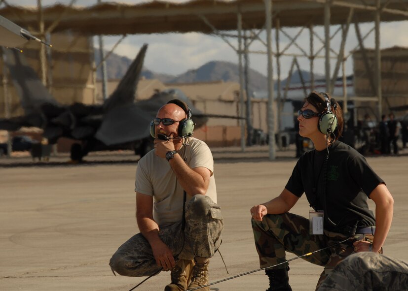 US Air Force Staff Sgt. Gary Smith is communicating to a pilot while Technical Sgt. Lisa Passon listens in at Nellis AFB on March 26th 2009. Both members are part of the 174th FW Syracuse, NY and are on their last scheduled deployment as an F-16 unit. (US Air Force photo by SSgt. Ricky Best/RELEASED)
