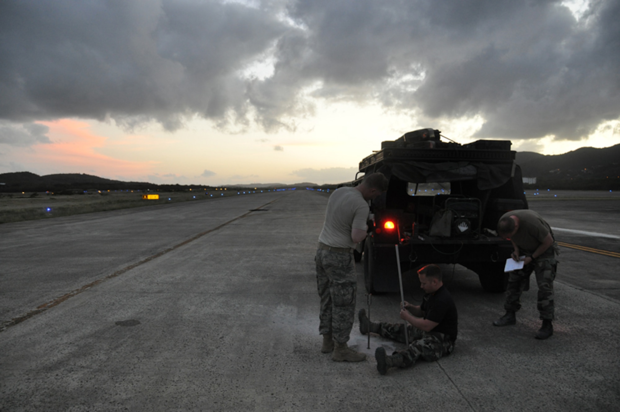 (From left to right) Capt. Brian Loveless, Staff Sgt. Joseph Reed and Capt. Luke Stumme, members of the 817th Contingency Response Group's "Alpha Mike" airfield assessment team, conduct soil density tests beneath a runway during the Vigilant Guard exercise in Puerto Rico, March 23-29. The completed assessment will be used "real-world" to certify the runway for use by various mobility aircraft. (U.S. Air Force photo/1st Lt. Dustin Doyle)
