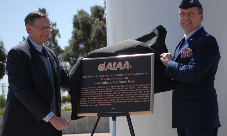 VANDENBERG AIR FORCE BASE, Calif. -- Maj. Gen. (Ret.) Bob Dickman and Col. David Buck, the 30th Space Wing commander, unveil a plaque presented to Vandenberg by the American Institute of Aeronautics and Astronautics for its contributions to space. (Air Force Photo/Senior Airman Wesley Carter)  