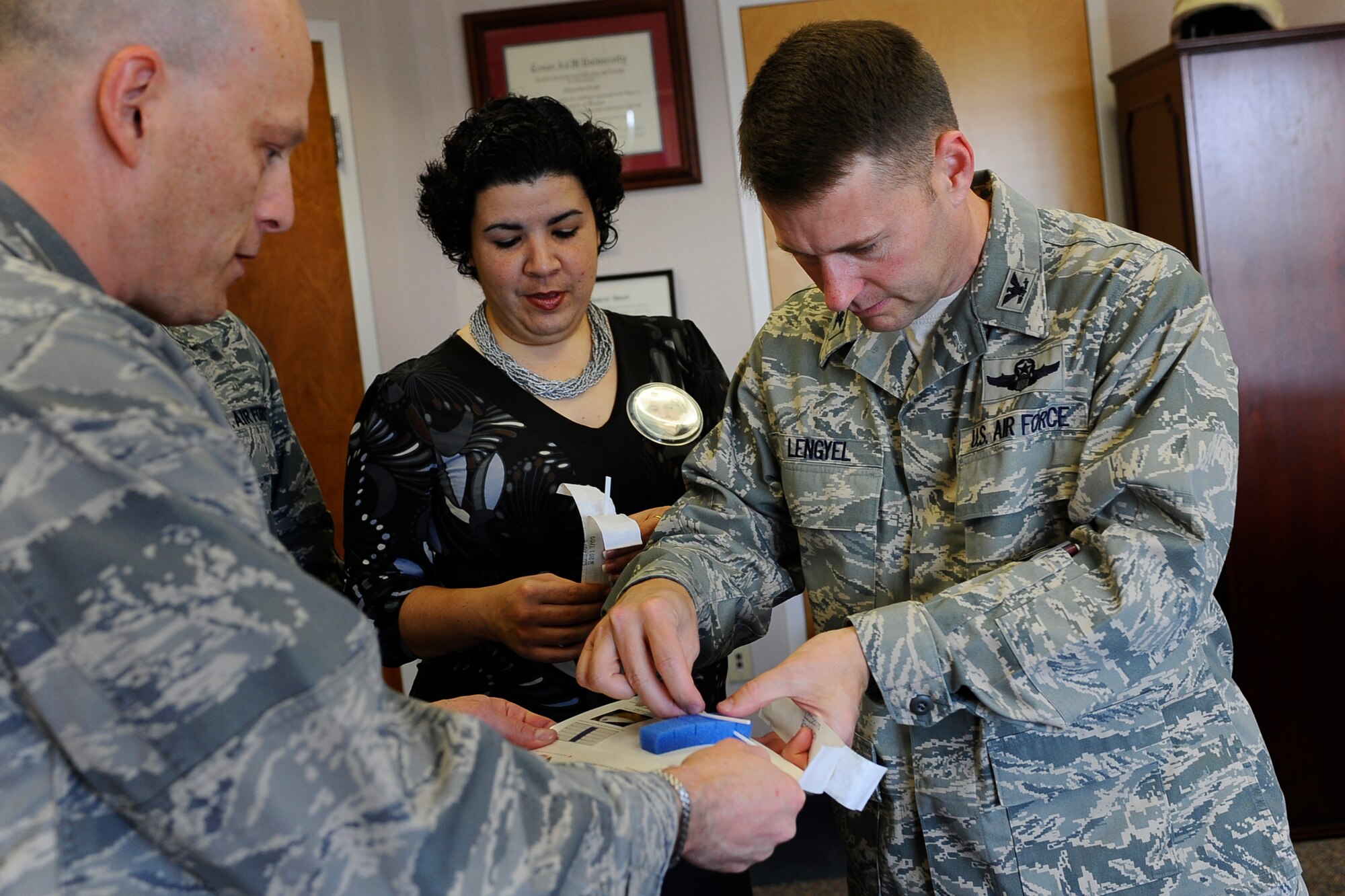 Col. Greg Lengyel, 1st Special Operations Wing commander, assisted by Capt. Mark Noon, 1st Special Operations Medical Group, and Diane Rodriguez. prepares to get a saliva swab to become a member of the National Marrow Donor Program registry, which assists families dealing with chronic illnesses in finding potential bone marrow donors. The C.W. Bill Young Department of Defense Marrow Donor Program, a partner of the National program, advocates military volunteer donors and will host drives at Hurlburt Field and Eglin Air Force Base April 8 and 9, respectively. (U.S. Air Force photo by Senior Airman Julianne Showalter)