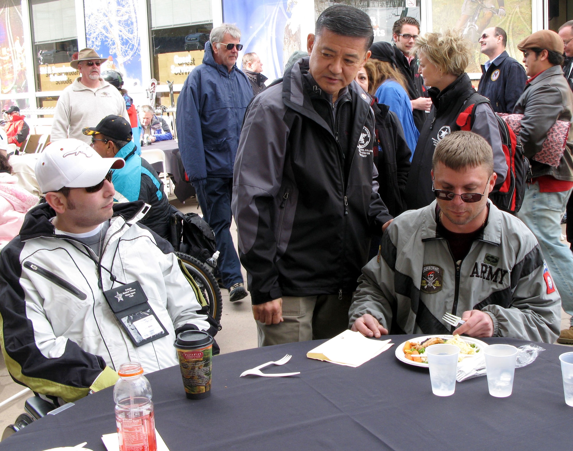 Veterans Affairs Secretary Eric K. Shinseki (center) chats with participants in the 23rd annual National Disabled Veterans Winter Sports Clinic at Snowmass Village, Colo., during a March 29 "Taste of Aspen" celebration that kicked off the six-day event.  Among participating veterans are retired Army Cpl. Allen Babin (left), an 82nd Airborne Division soldier who suffered a traumatic brain injury during operations in Iraq in 2003, and Army Pfc. Chris Lynch (right), who suffered a traumatic brain injury during a 2000 training accident in France. (Defense Department photo/Donna Miles)
