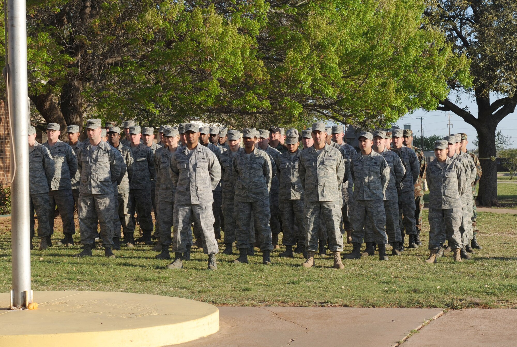 DYESS AIR FORCE BASE,TX-- Airmen from the 7th Logistics Readiness Squadron stand in formation in front of the U.S. flag at Saint John's Elementary here, March 31. The event was put on by the school to salute members of the Armed Forces. (U.S. Air Force photo by Senior Airman Domonique Simmons)