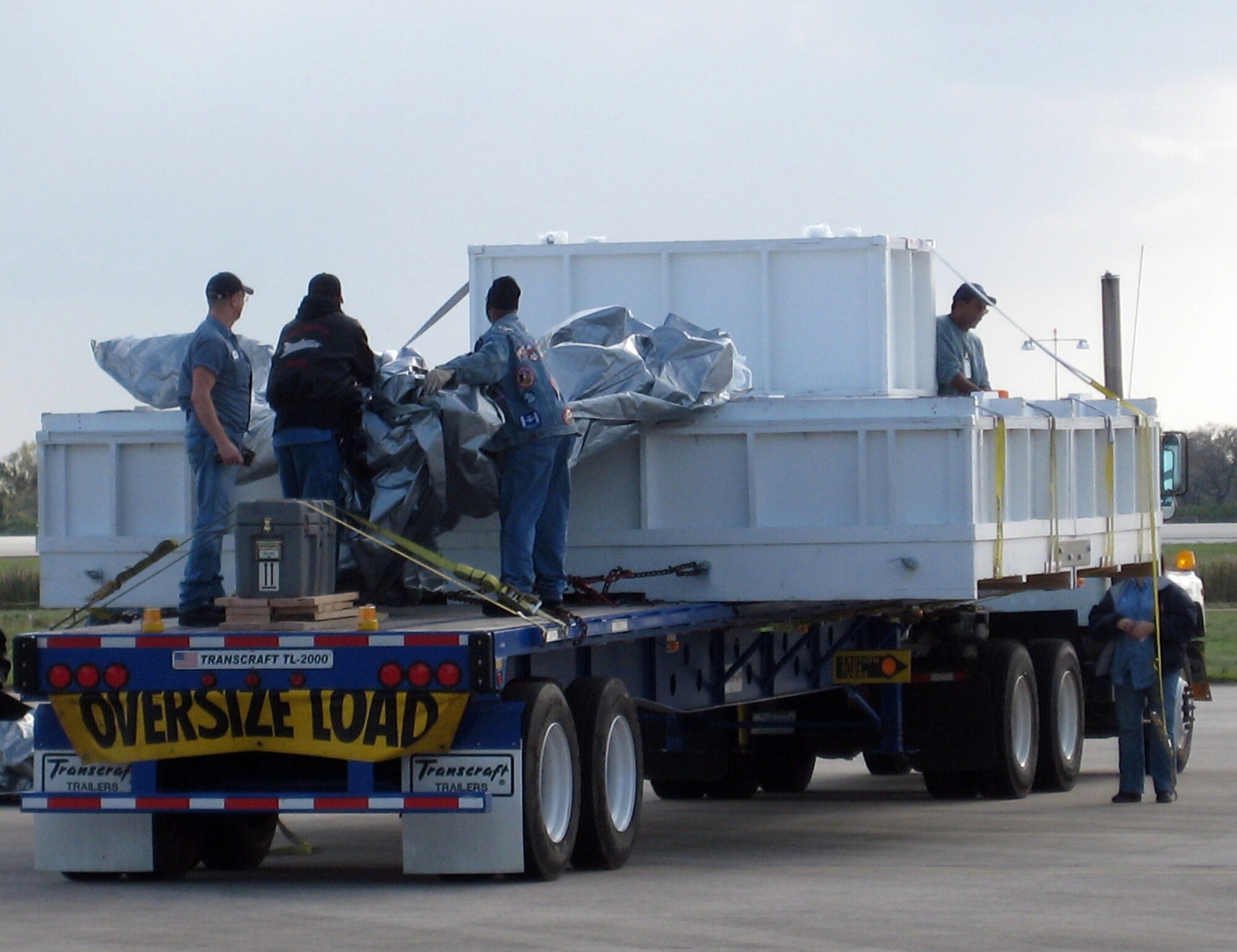 NASA personnel take the tarp off an ExPRESS Logistics Carrier at Andrews Air Force Base, Md., preparing it for loading onto a Dover Air Force Base, Del., C-17 March 21. An Air Force Reserve aircrew with 326th Airlift Squadron flew the ELC to the Kennedy Space Center, Fla., for transport to the International Space Station via the Space Shuttle. ELCs are unpressurized facilities attached to the ISS and are used for science experiments, storage devices and for electrical power. (U.S. Air Force photo)
